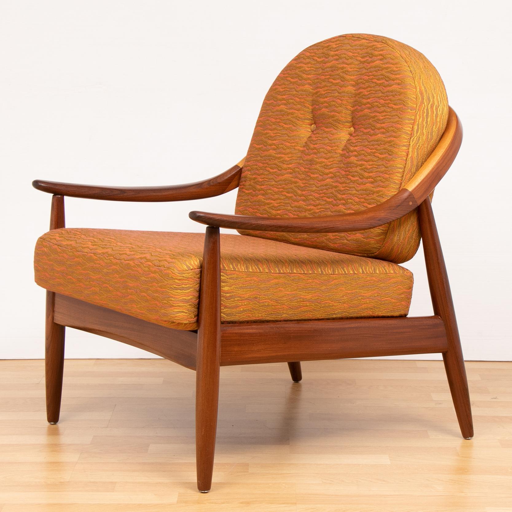 1960s Greaves and Thomas teak bentwood armchair. The chair is formed from steam bent solid teak with curved sweeping armrests and a flared spindle back. The legs are constructed from turned, tapered, flared legs. The seat and buttoned back cushion
