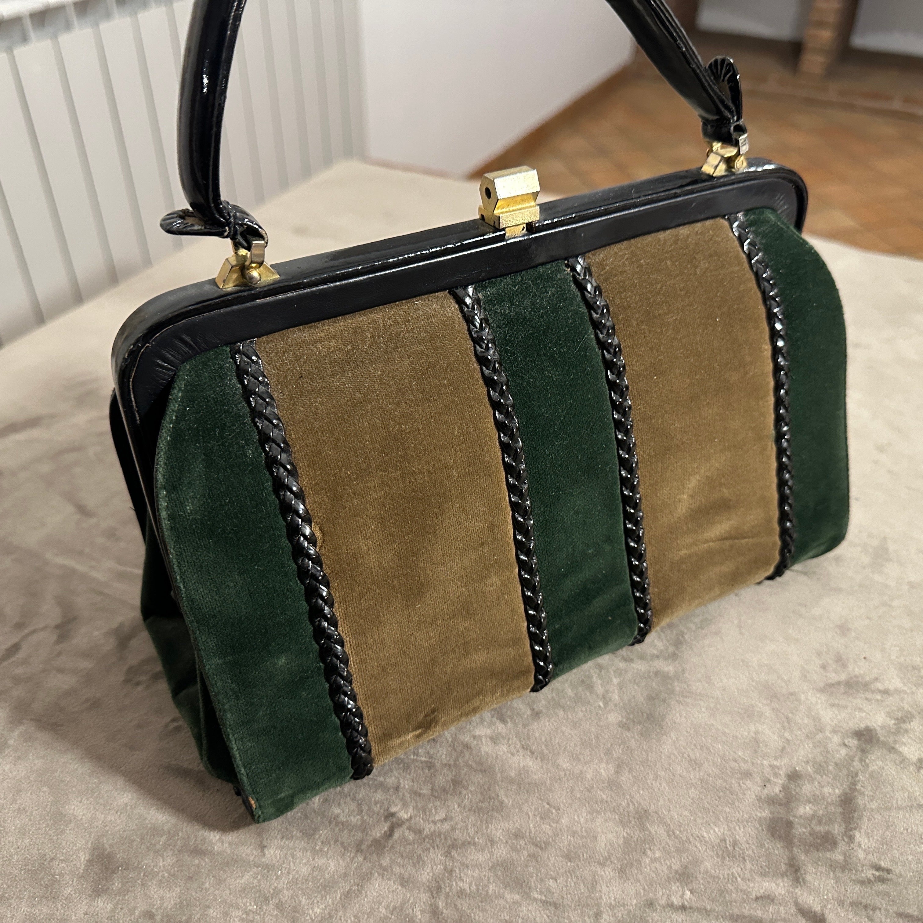 Cette pièce associe des matériaux luxueux dans un motif color block saisissant, fabriqué à partir d'une belle combinaison de daim vert foncé riche et de cuir lisse marron chocolat. Cette association crée un contraste élégant en termes de couleur et