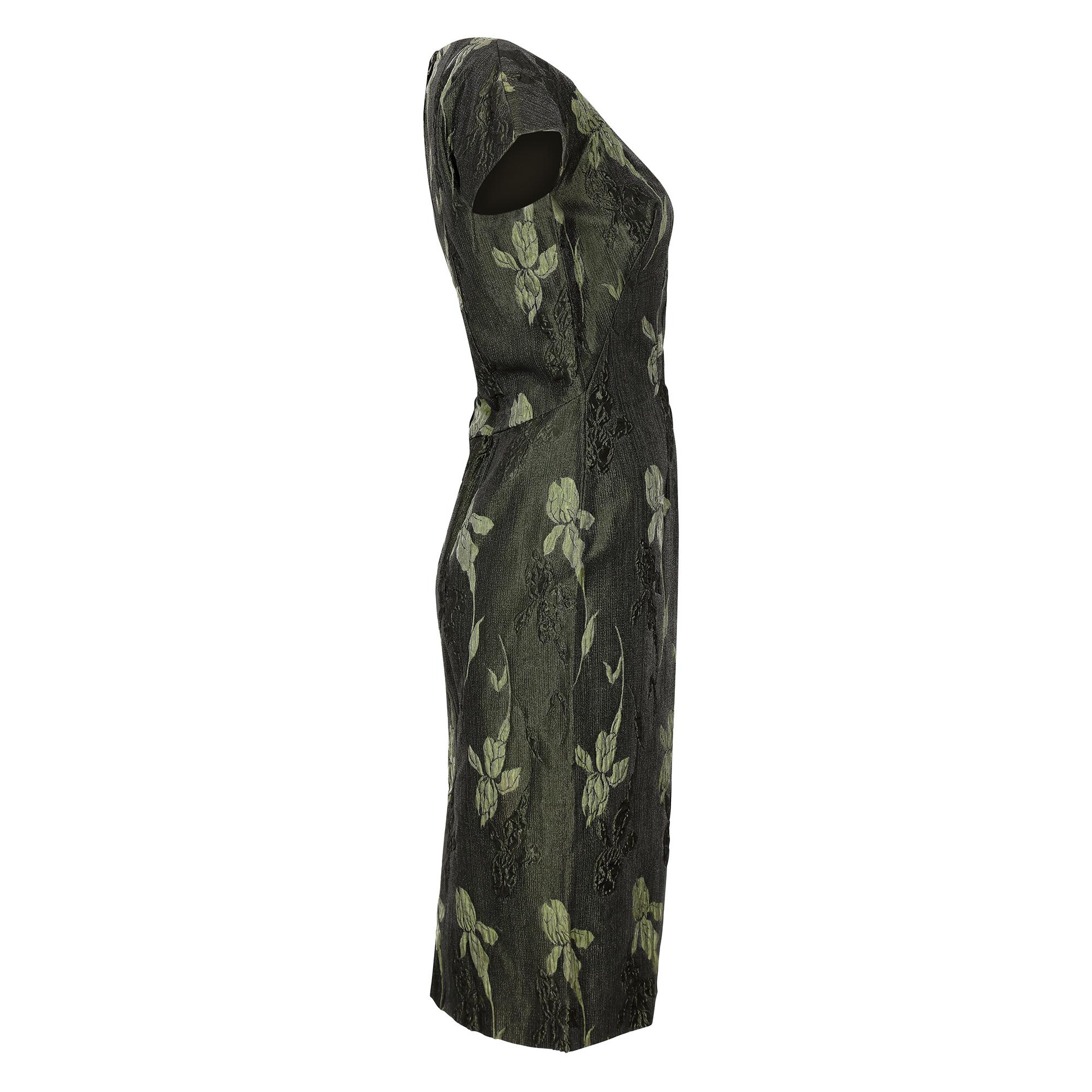 This elegant vintage 1960s metallic evening dress is of high-end, British manufactured quality although unlabelled. The opulent and textured brocade fabric has an iris design in alternating two-tone forest green which shimmers in the light with