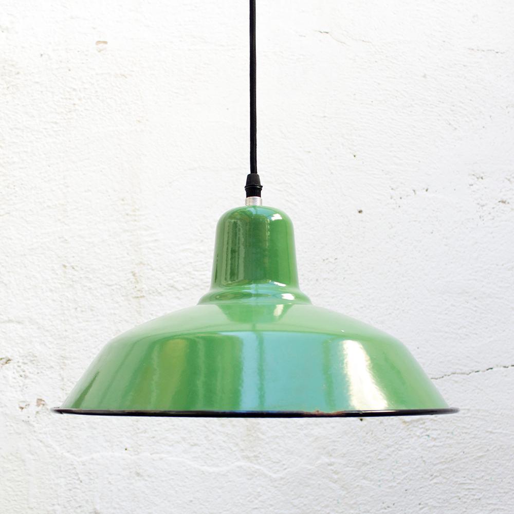 Add some color to the room with this bright green hanging ceiling light. From a skinny base, the shade jets out to be wide and shallow with a single light bulb inside. The steel material is finished with a glossy medium green color, a black rim, and