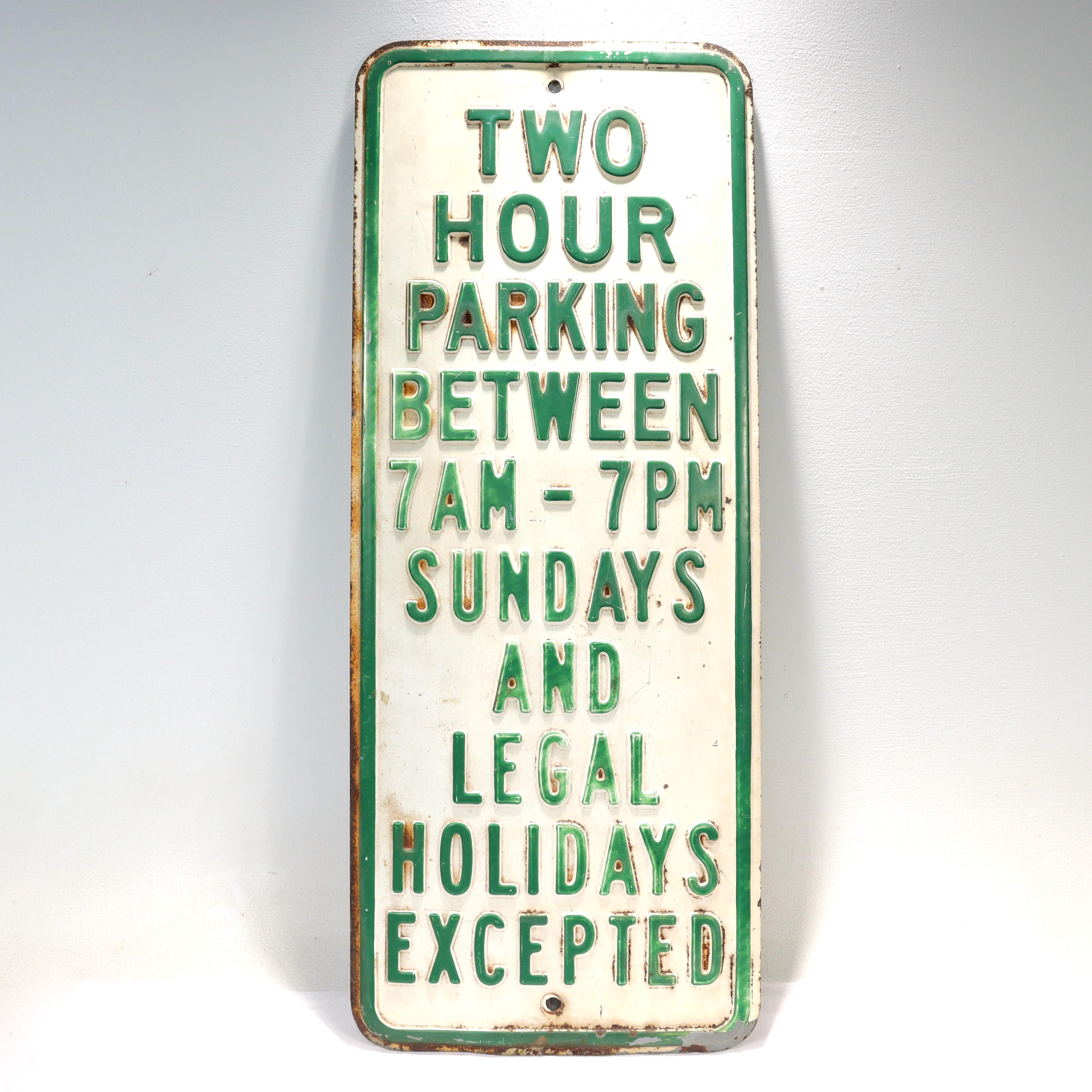 A fine vintage traffic or street sign.

With green text and border on a white ground.

The text reads: 

'TWO HOUR PARKING BETWEEN 7AM - 7PM SUNDAYS AND LEGAL HOLIDAYS EXCEPTED'. 

Simply a great vintage sign!

Date:
20th