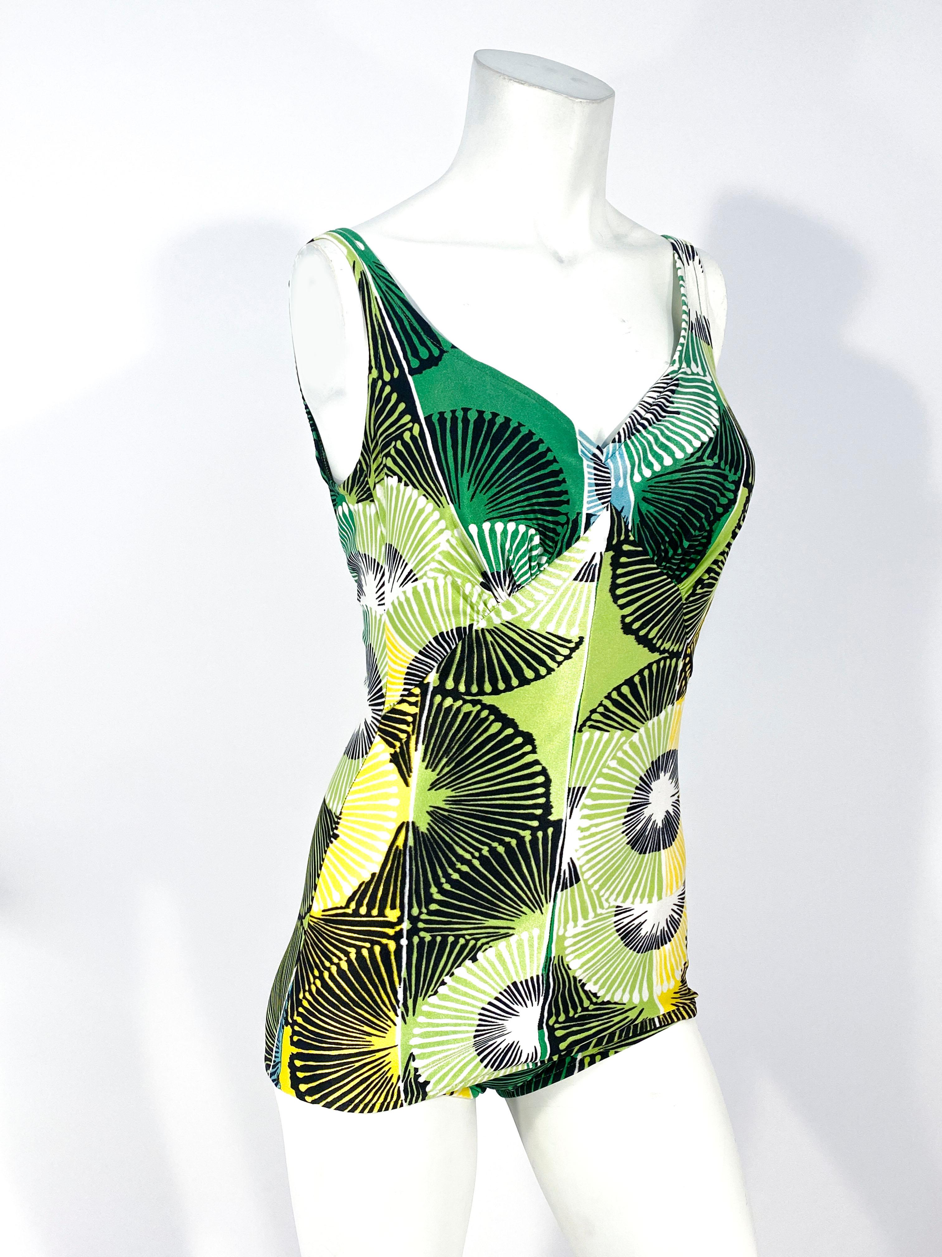 1960s Hawaiian & modernistic printed bathing suit in several shades of green and yellow. Under the bust there is a pleated gather and back has a very low back.  The bust has an inner bra structure for support. 
