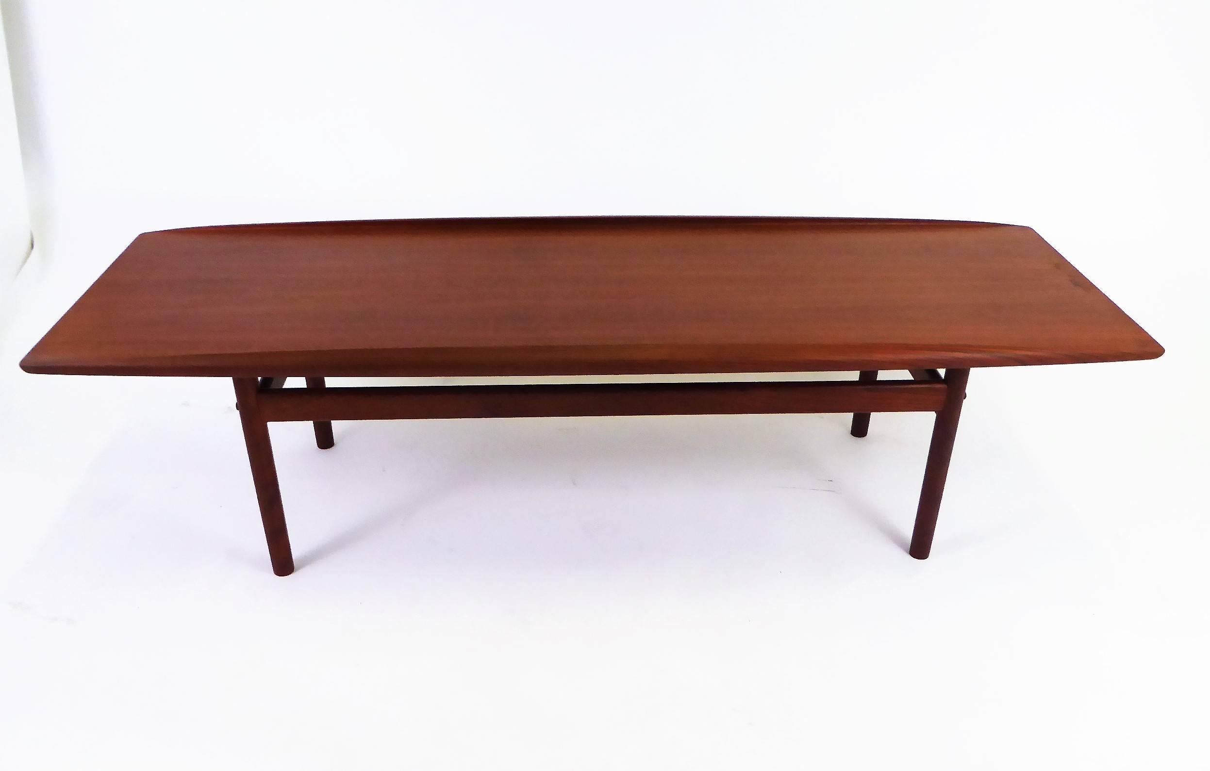 Exceptional 1960s Danish design by Grete Jalk for Poul Jeppesen. A surfboard coffee table in teak with sculpted edge form. With appropriate 1960s Jalk/Jeppesen labels, the table is without issues. One off colored spot on one end (see