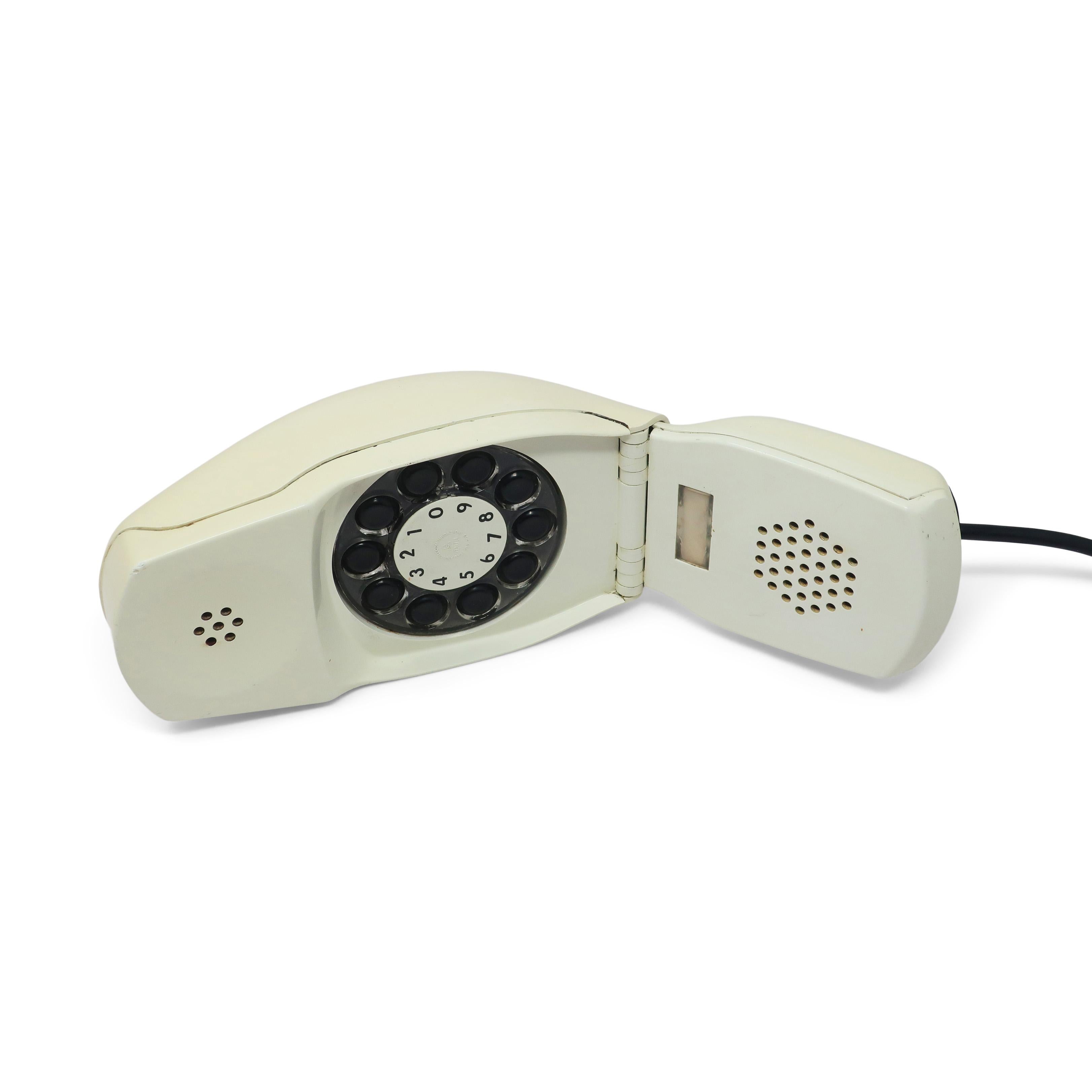 An off-white Grillo (Cricket) folding telephone by Marco Zanuso and Richard Sapper designed in 1966.  A revolutionary space age modern design with an ingenious flip mechanism and a low-profile that resembles a computer mouse.  Can be found in the