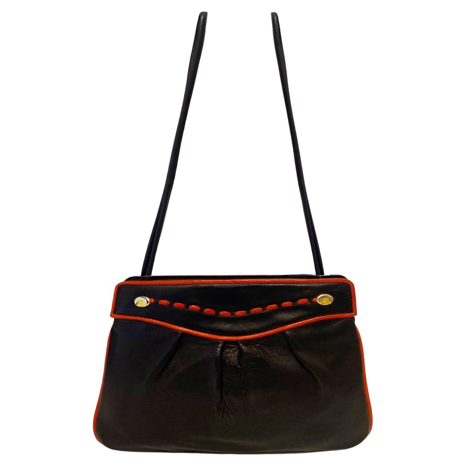 1960's Gucci Black Leather Shoulder Bag, double leather straps that run around the top of the bag, red leather line detailing, double logo in gold-tine metal badges, double compartments, clutch closure, Made in Italy by Gucci, 100% leather The