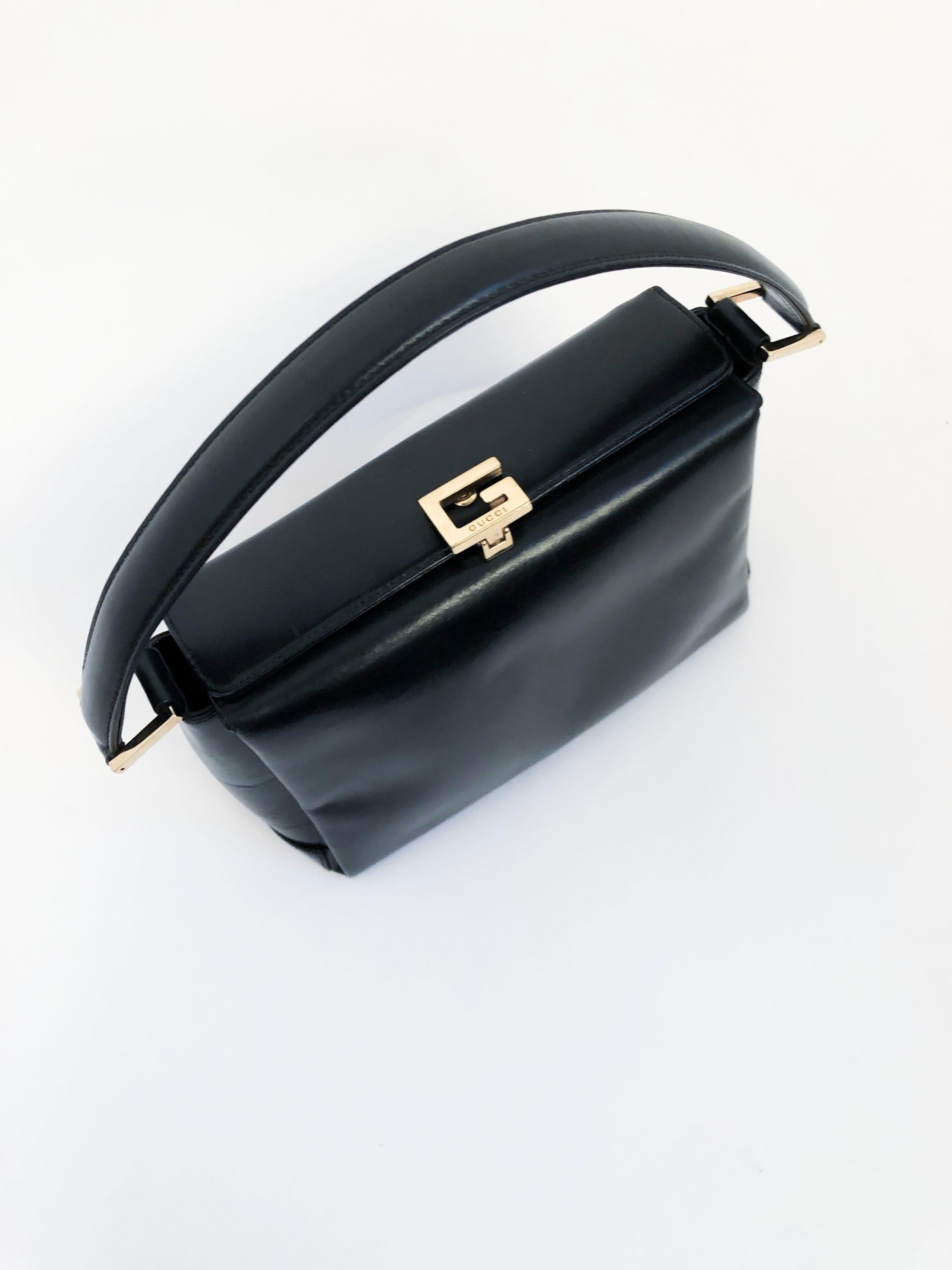 Black Gucci leather handbag with bras hardware and a latch closure with the Gucci 