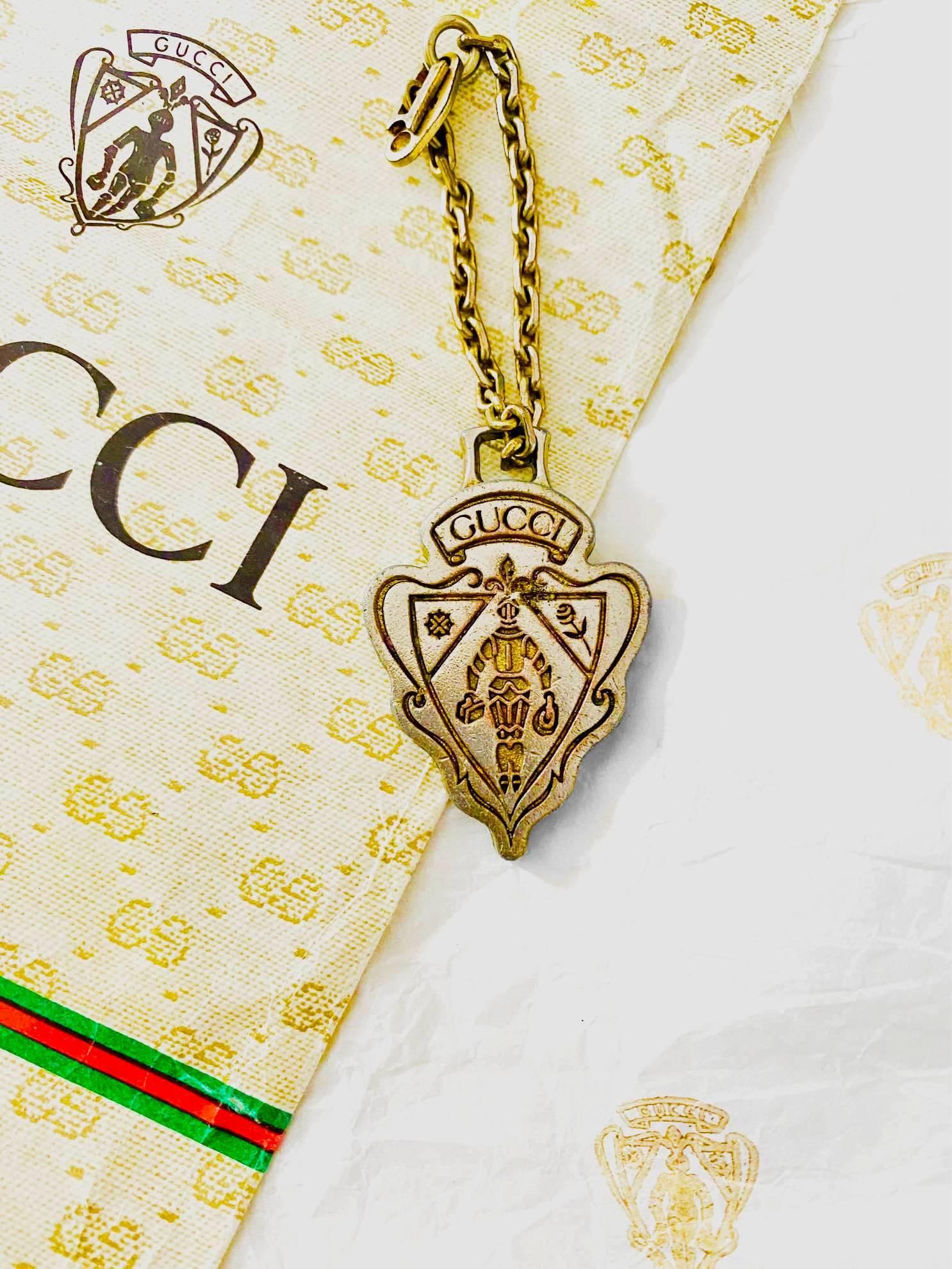 Der Gucci-Schlüsselanhänger mit Metallemblem aus den 1960er Jahren verleiht jedem Look eine zeitlose Eleganz. Sie ist aus hochwertigem, goldfarbenem Messing gefertigt und verfügt über eine klassische Kette mit Schnalle, die für lange Haltbarkeit