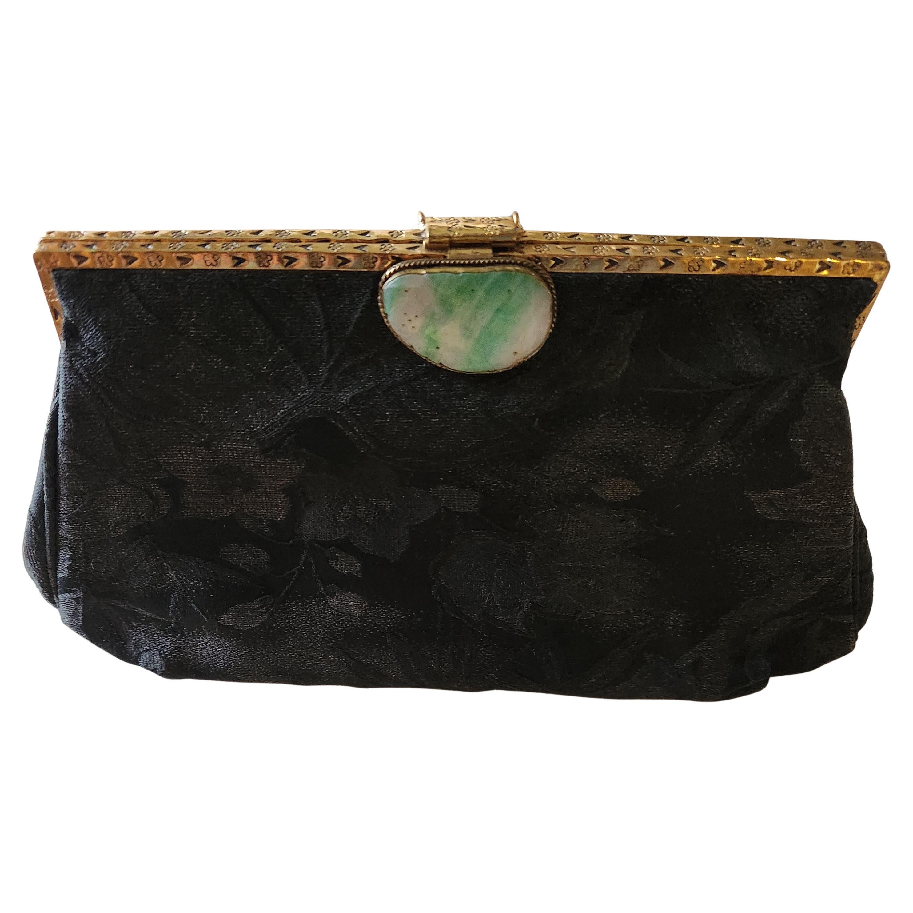 1960s Gump's San Francisco Black Clutch Bag Jade Clasp
floral silk brocade pattern
antiqued gold tone hardware
Stylish wristlet strap
Silk lining 
interior pocket
approximately 6 h x 9 w x 1.5 d
Label present Gump's San Francisco / Hong