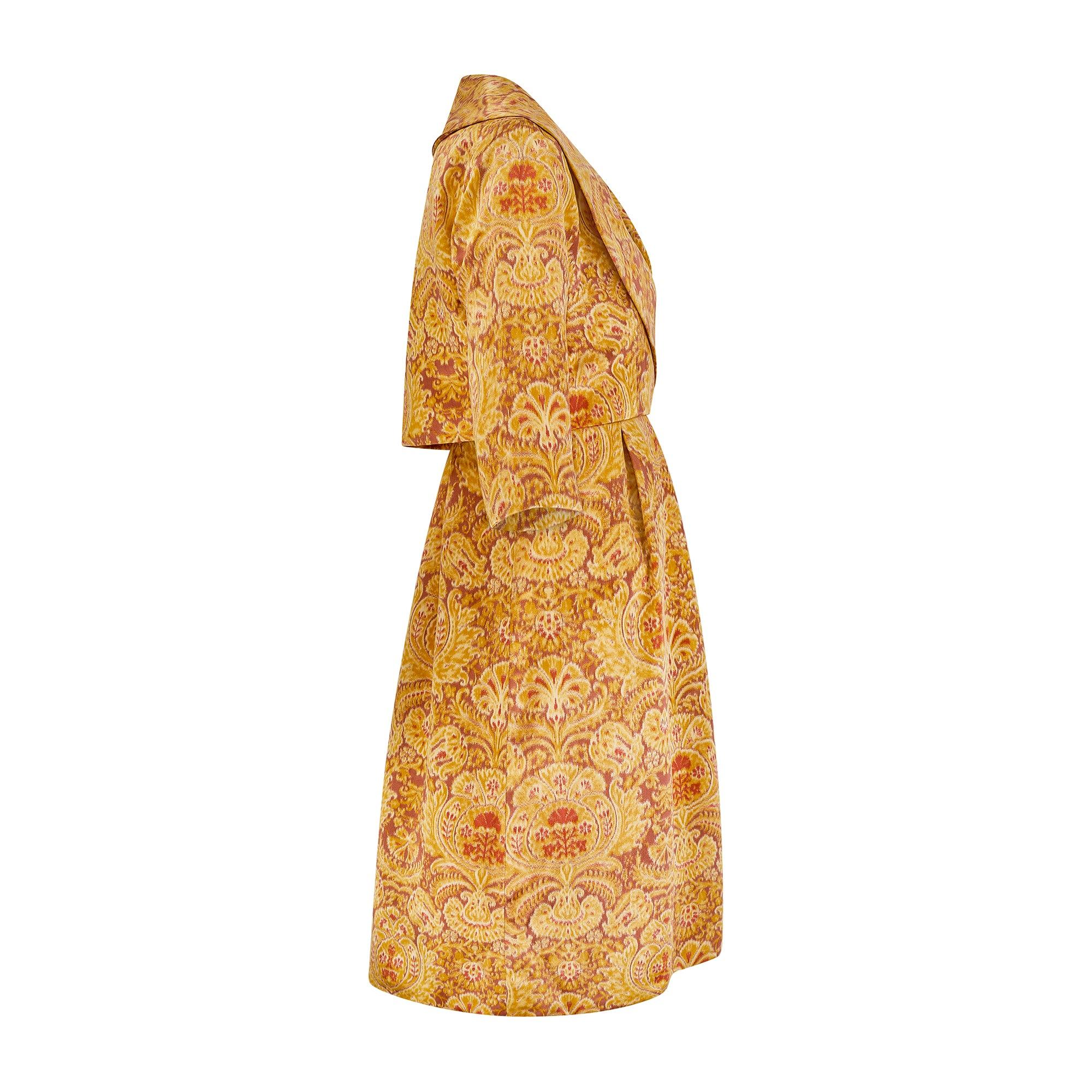 This stand-out, early to mid 1960s two-piece haute couture ensemble is by Guy Laroche and the construction is nothing short of superb. Composed of a dress and bolero jacket, it is hand-crafted from silk patterned with a golden heraldic print. The