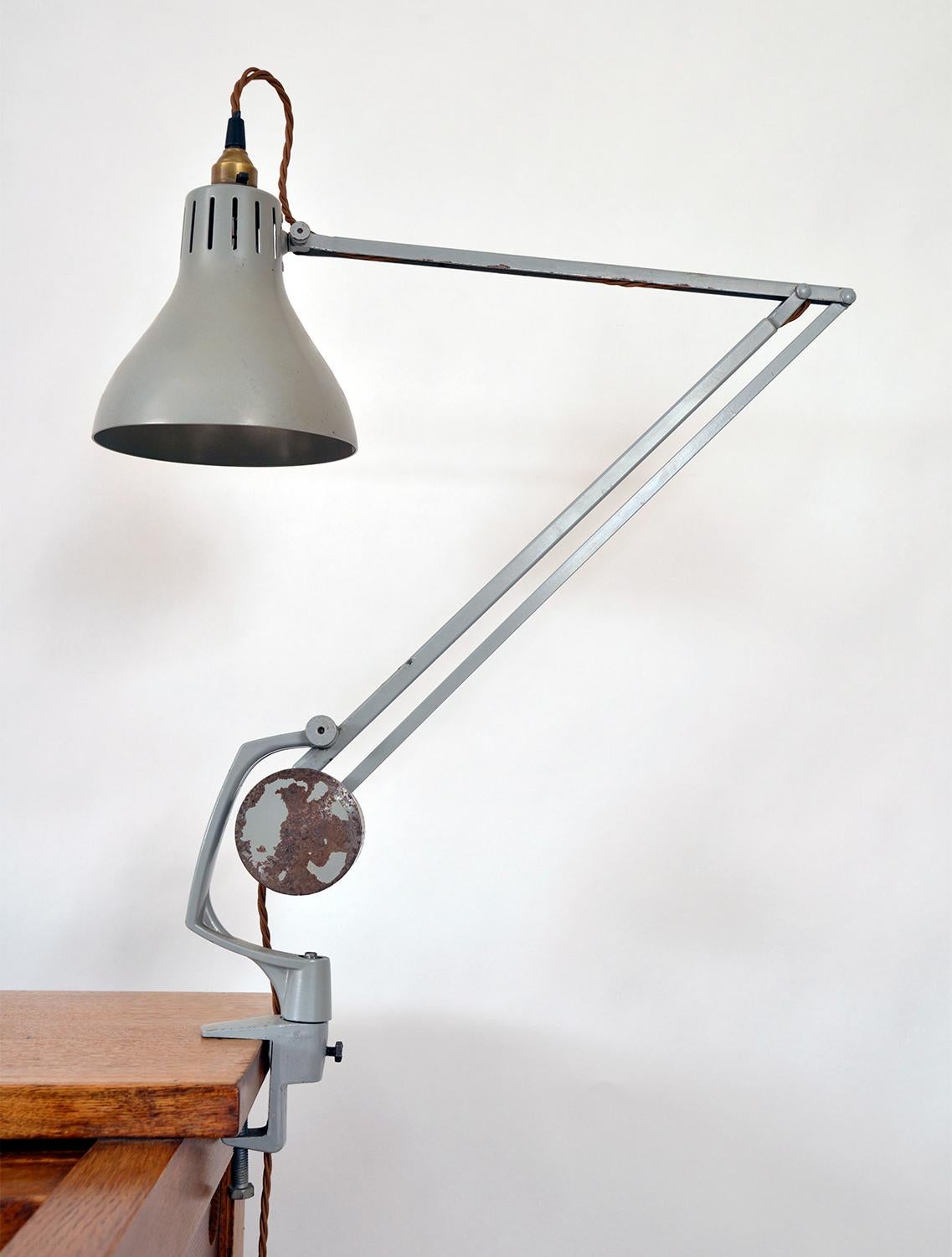 The Hadrill and Horstmann ‘Simplus’ desk mounted lamp – also known as the 'Roller' – was the architects and engineers prized possession of the era. 
A superb piece of Great British engineering, this articulated lamp simply clamps to a desk,