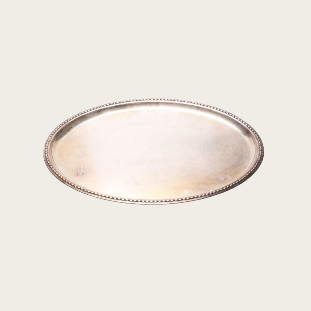 This 1960s hammered silver tray by C.G. Hallberg features a raised string of pearl-shaped border detail and is stamped with the designer’s mark on the underside.

19.5