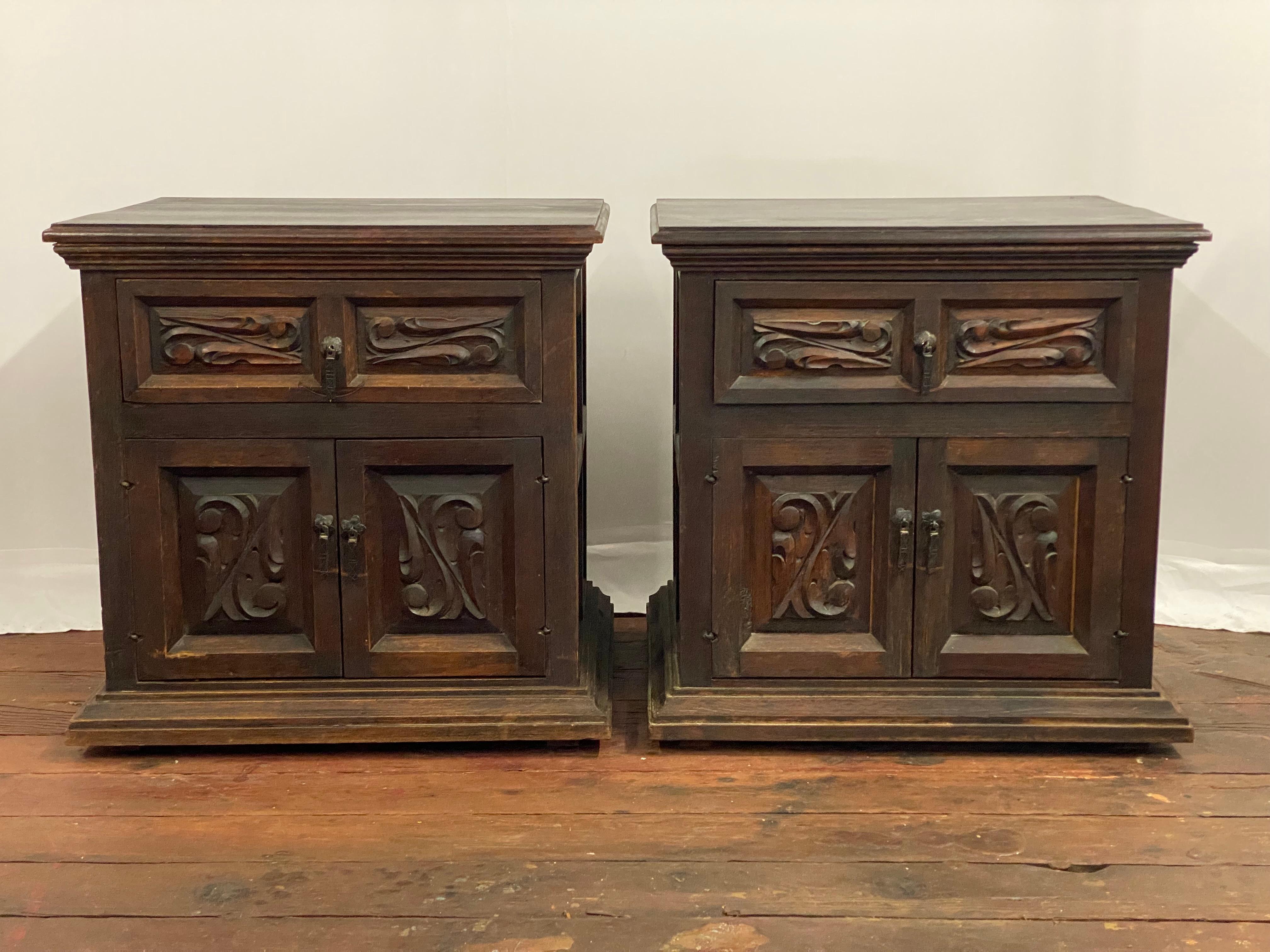 Paire de tables d'appoint de style Coloni espagnol des années 1960, avec panneaux en relief sculptés à la main. Un tiroir simple sur deux portes. Motif organique profondément sculpté à la main et panneaux biseautés sur les côtés, les portes et les