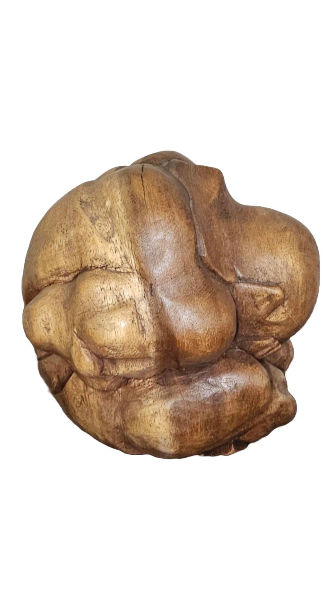 This striking hand-carved wooden sculpture from the 1960s captures the poignant image of the Weeping Buddha, an evocative figure steeped in symbolism and history. The piece depicts a man in a contemplative pose, embodying both prayer and sorrow. Its