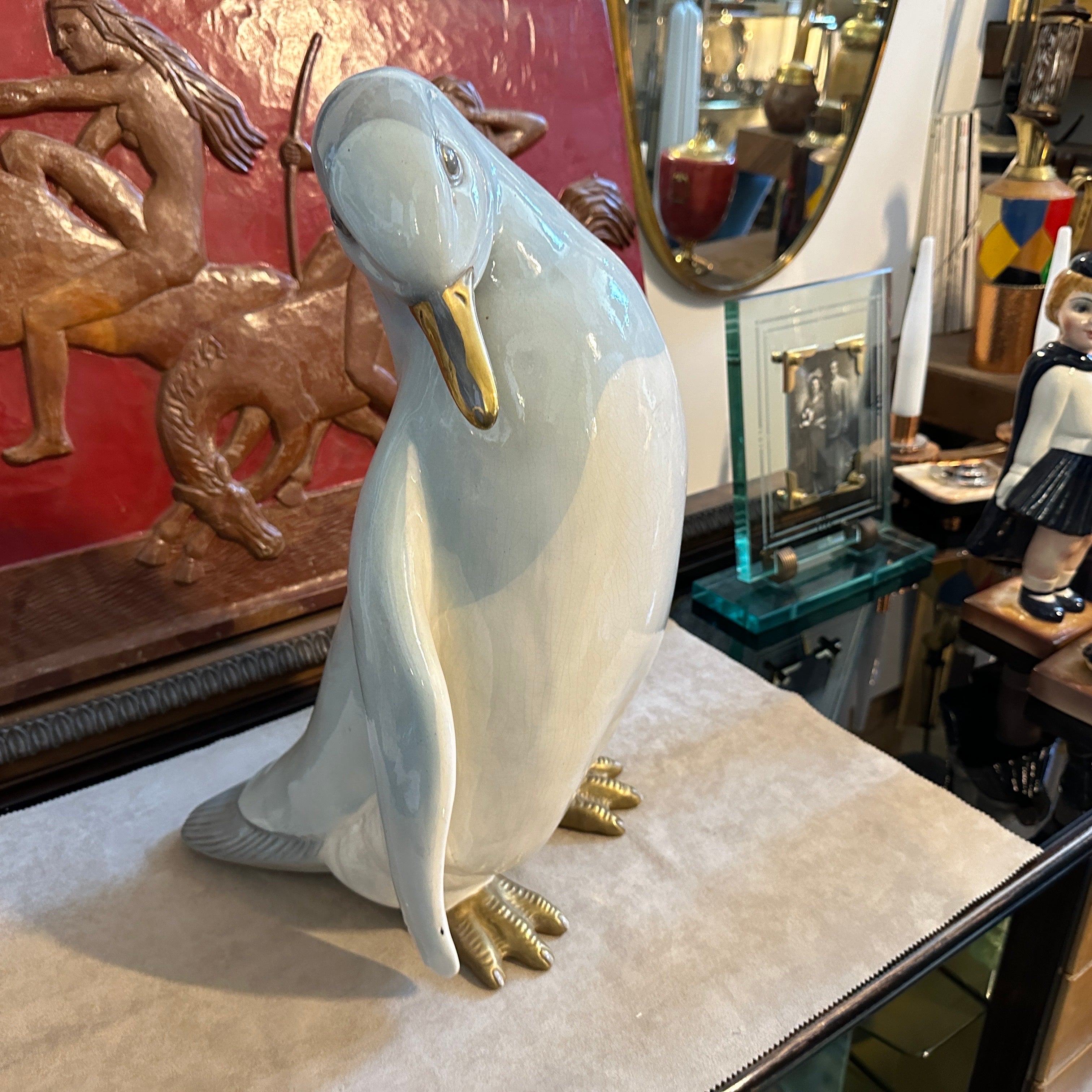 The 1960s hand-crafted porcelain figure of a penguin by Ronzan is a charming and meticulously detailed piece of Italian artistry. This figure showcases a realistic and expressive depiction of a penguin, capturing the bird's unique characteristics
