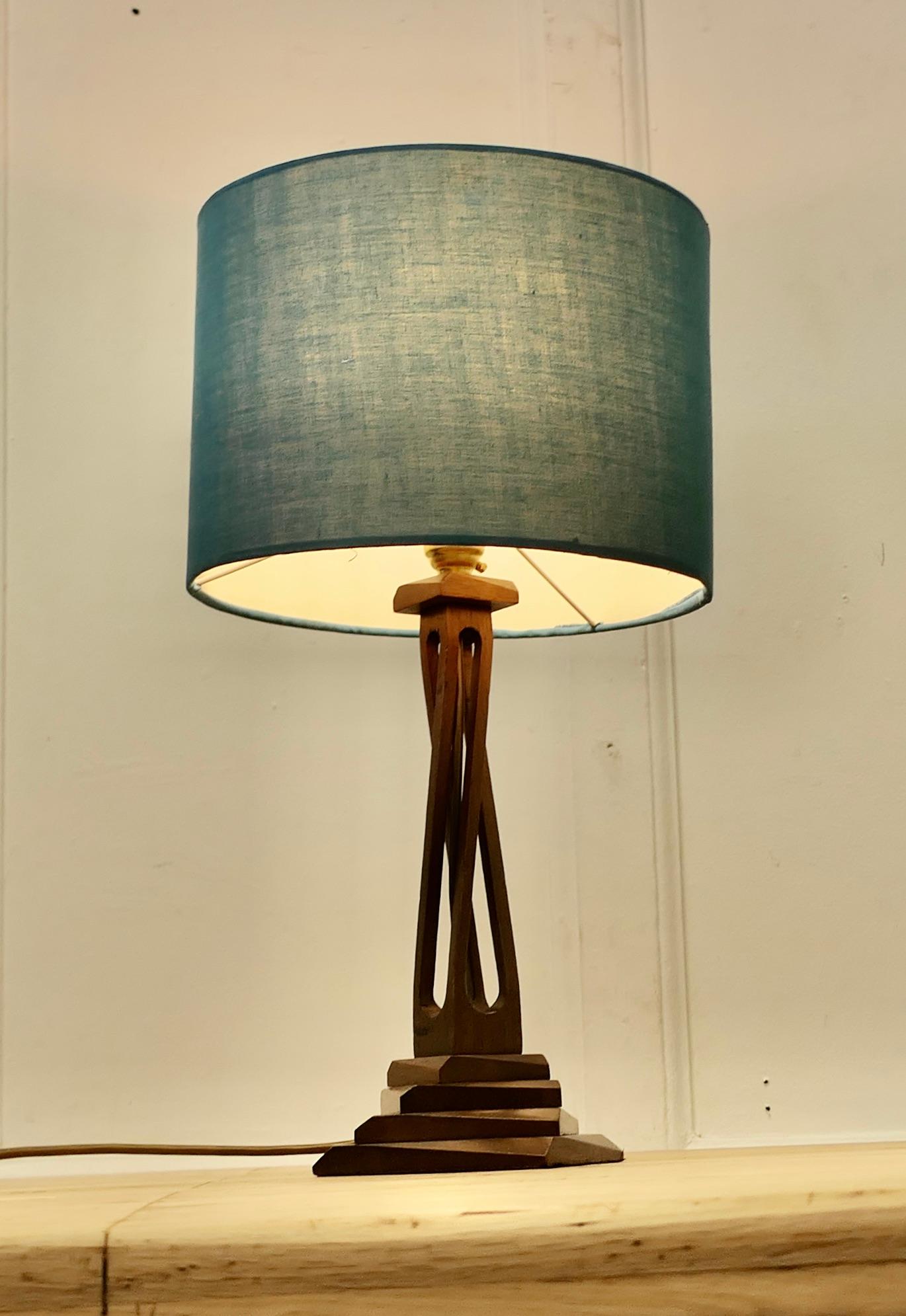 Lampe de table moderniste des années 1960, sculptée à la main

La base de la lampe est sculptée d'une base asymétrique à 4 niveaux avec une colonne ouverte à triple torsion. La lampe est livrée avec un abat-jour contemporain en lin bleu paon. 
La