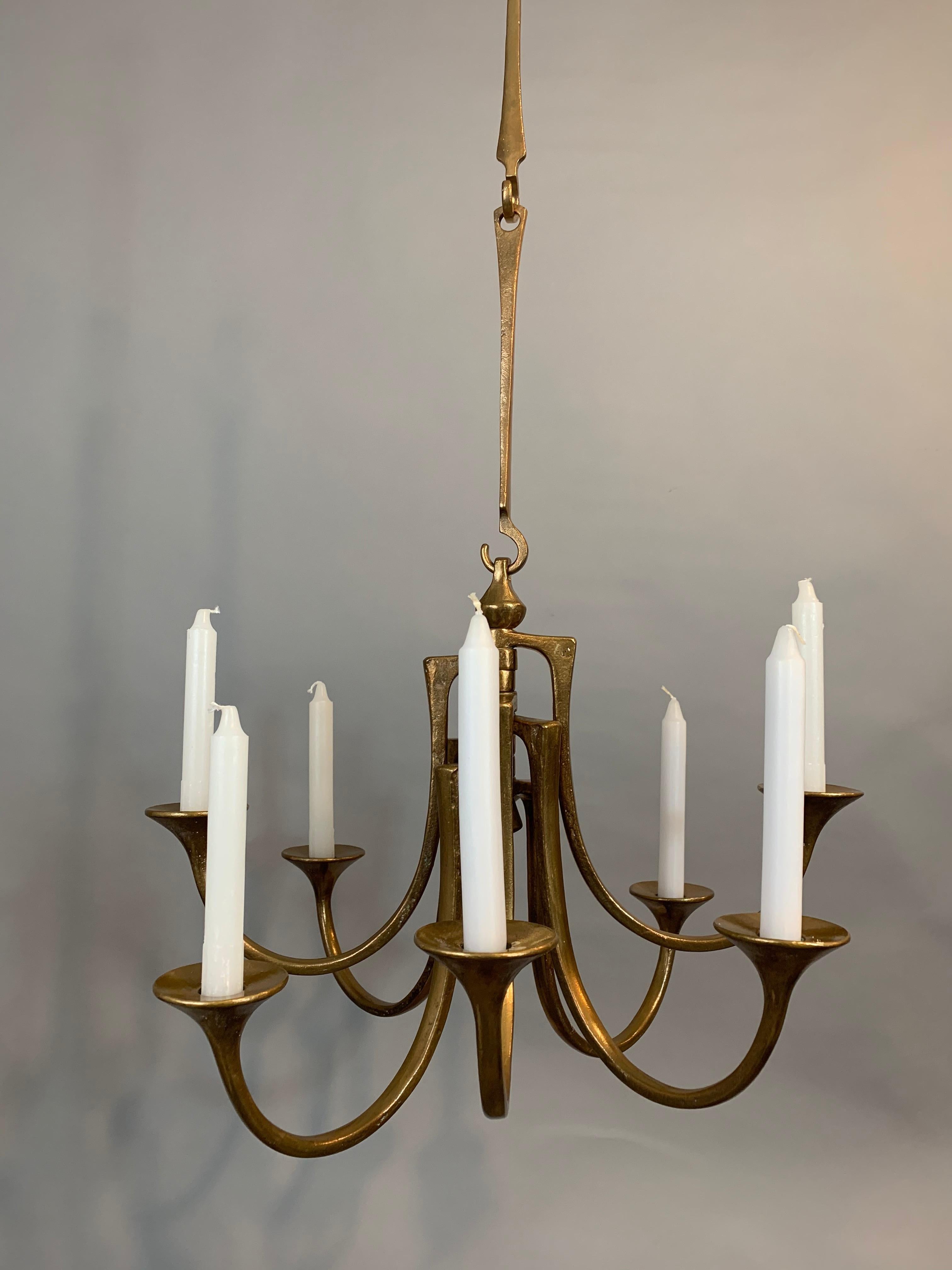 1960s Brutalist hanging bronze pendant candleholder designed by Michael Harjes and produced by Harjes Metalkunst in Germany. The piece is composed of 8 cast-bronze arms which hold one candle in each one. The candleholder is suspended from bronze