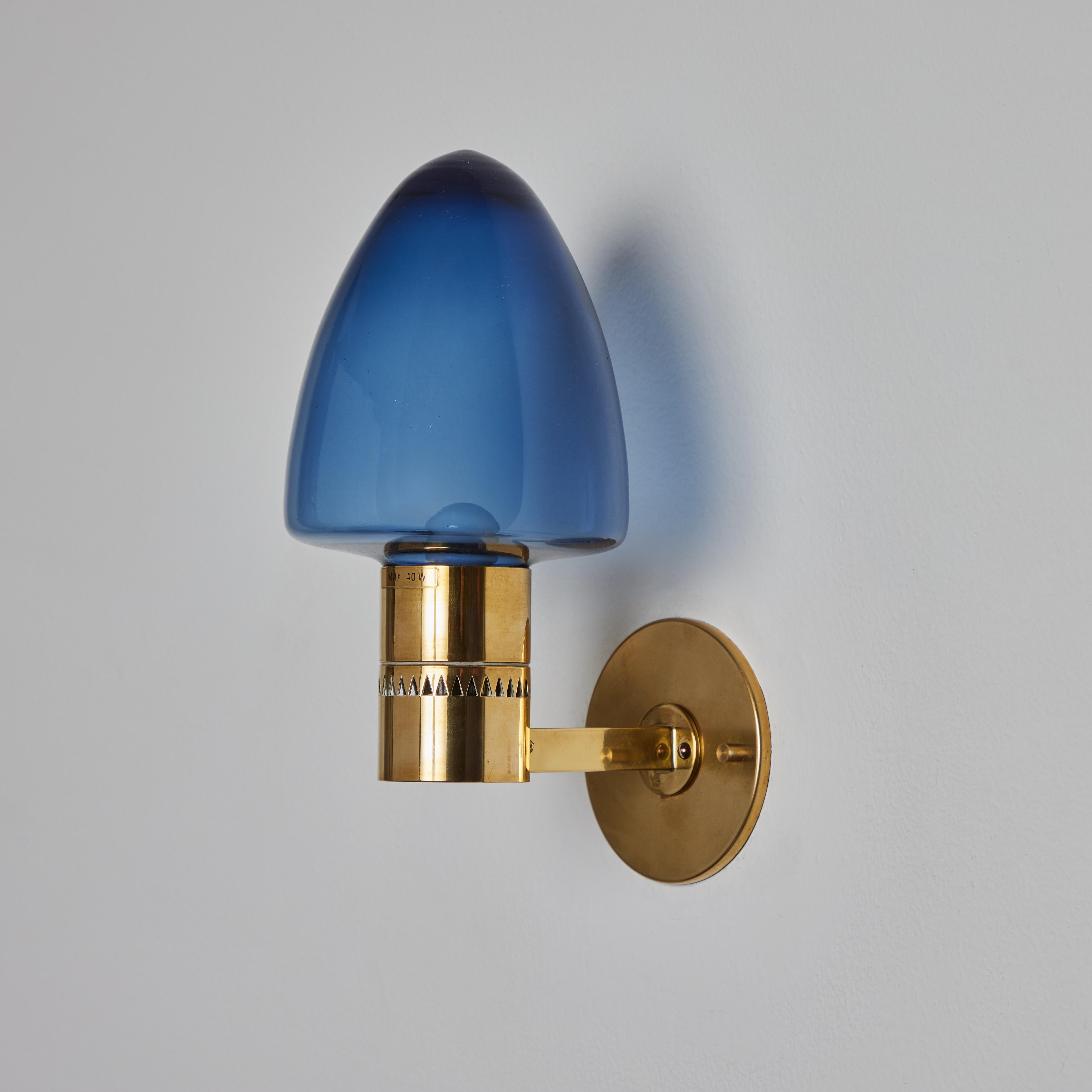 1960 Hans-Agne Jakobsson Model V-220 Brass & Blue Glass Sconce for Markaryd. Un design vintage incroyablement raffiné, typiquement suédois. Exécuté en laiton courbé et en verre soufflé teinté bleu.

Convient à une ampoule LED à culot candélabre