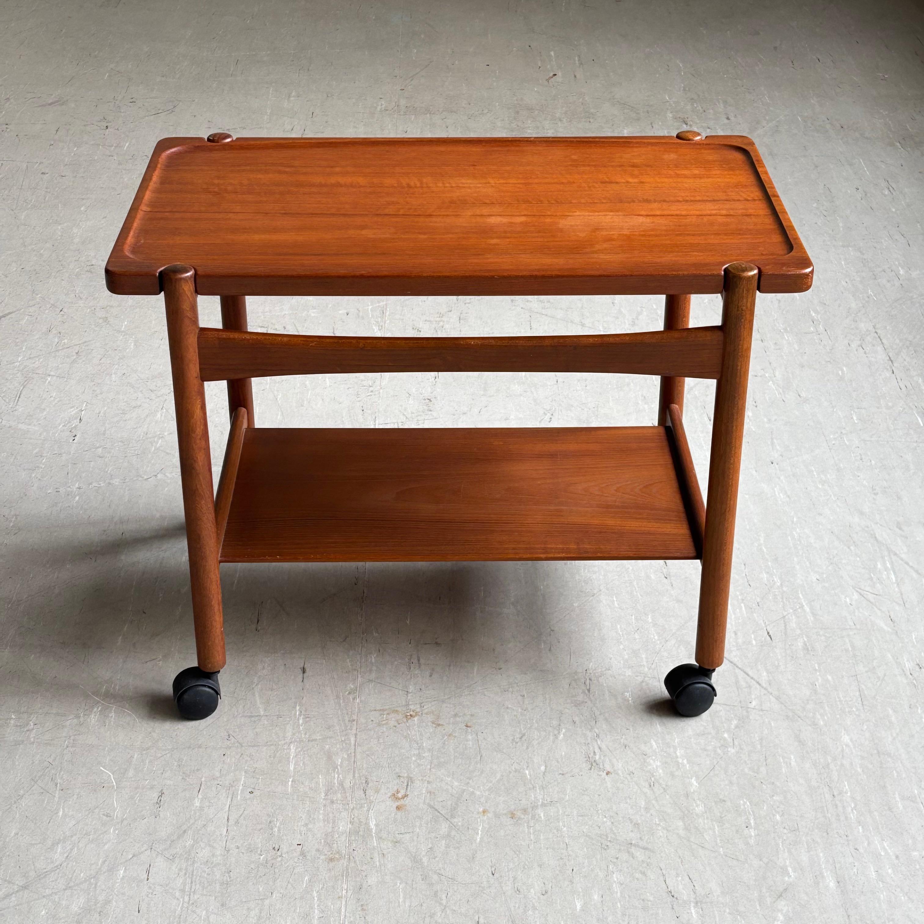 Hans J. Wegner AT-48, 1960, chariot de service / table en teck. Produit par Poul Jeppesen Möbelfabrik, Danemark. Le plateau de la table peut être retiré pour créer un plateau de service. Avec une étagère inférieure fixe. Sur des sous-verres.