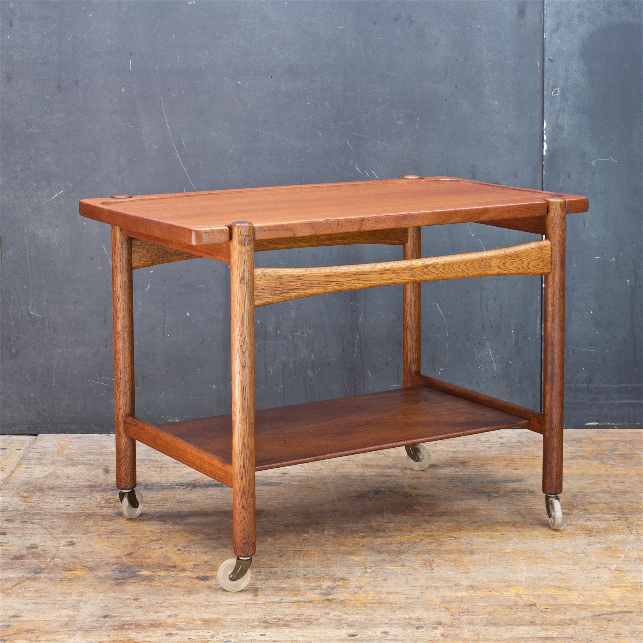 Wonderful and heavily patinated solid teak and solid oak serving trolly by Hans J. Wegner. We lightly refinished both side of the sold teak top board and deeply cleaned the rest. However the cart still retains a wonderful (well loved and used,) dark