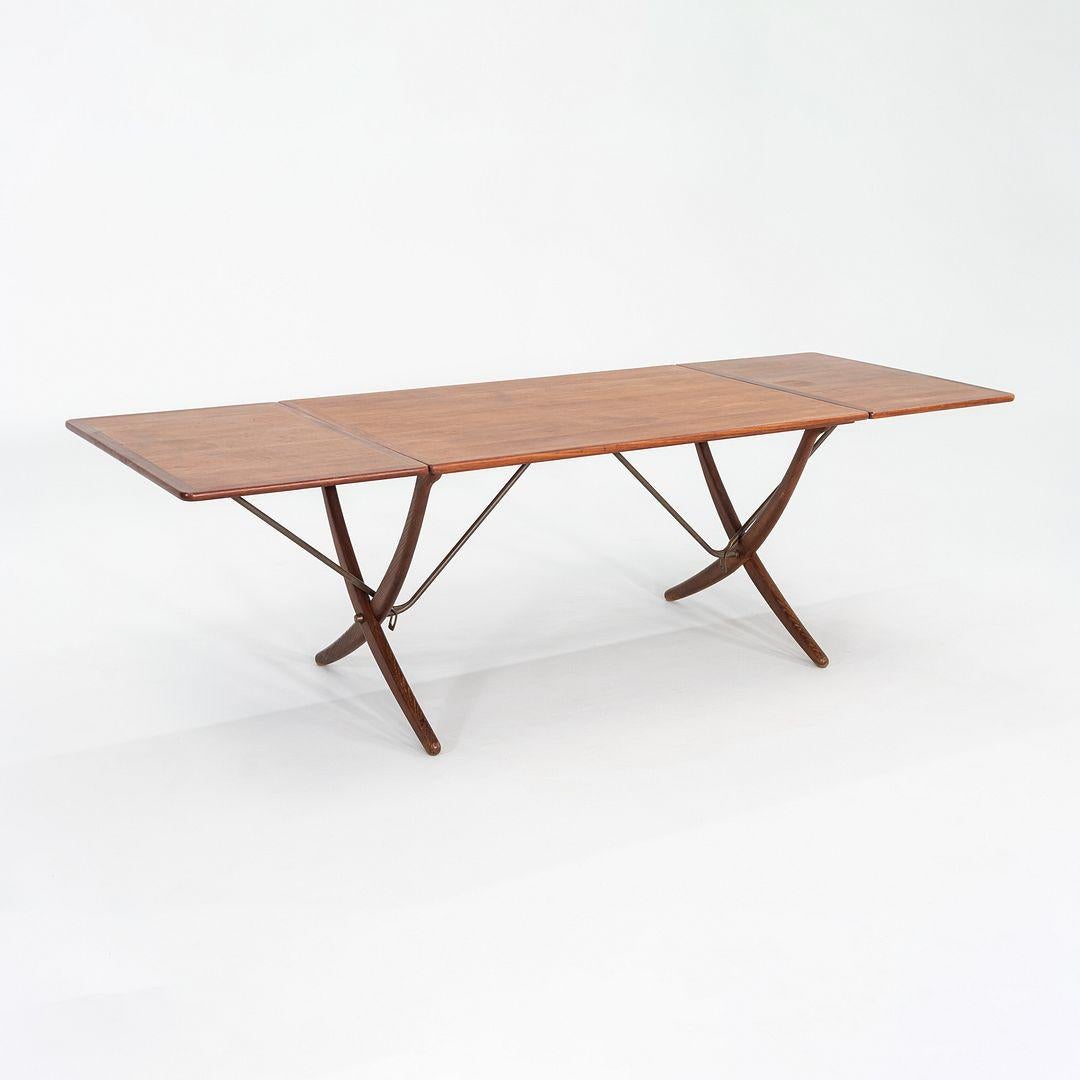This is an AT-304 Dining Table, originally designed by Hans Wegner for Andreas Tuck in 1950. This particular example was produced in Denmark and dates back to the 1960s. Crafted in teak with solid patinated oak legs, the table showcases Wegner's
