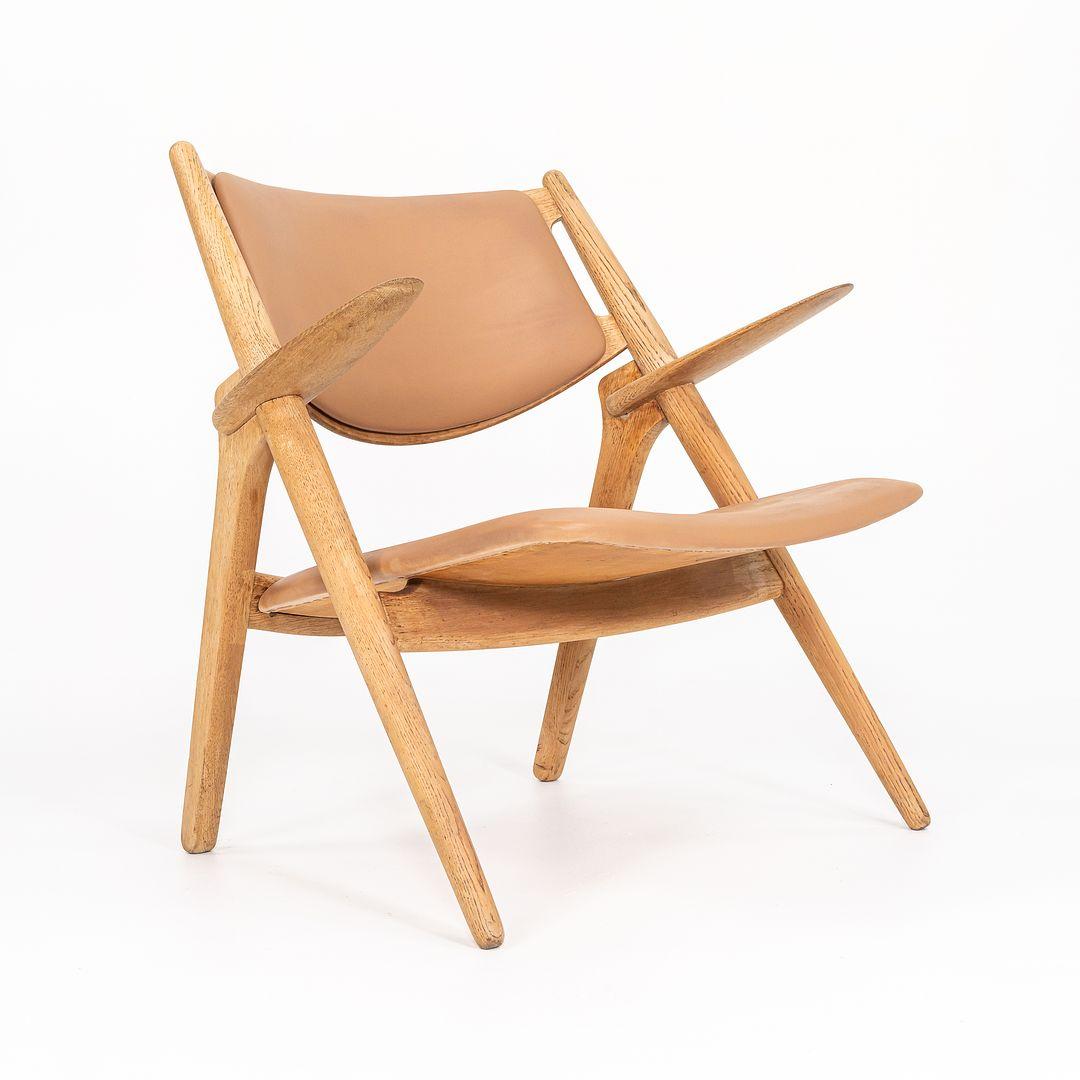 Dies ist ein Sawbuck Lounge Chair aus massiver Eiche, Modell CH28P, entworfen von Hans Wegner im Jahr 1951. Dieses besondere Stück wurde von Carl Hansen & S√∏n in den 1960er Jahren hergestellt. Das Design besteht aus einem massiven Gestell aus