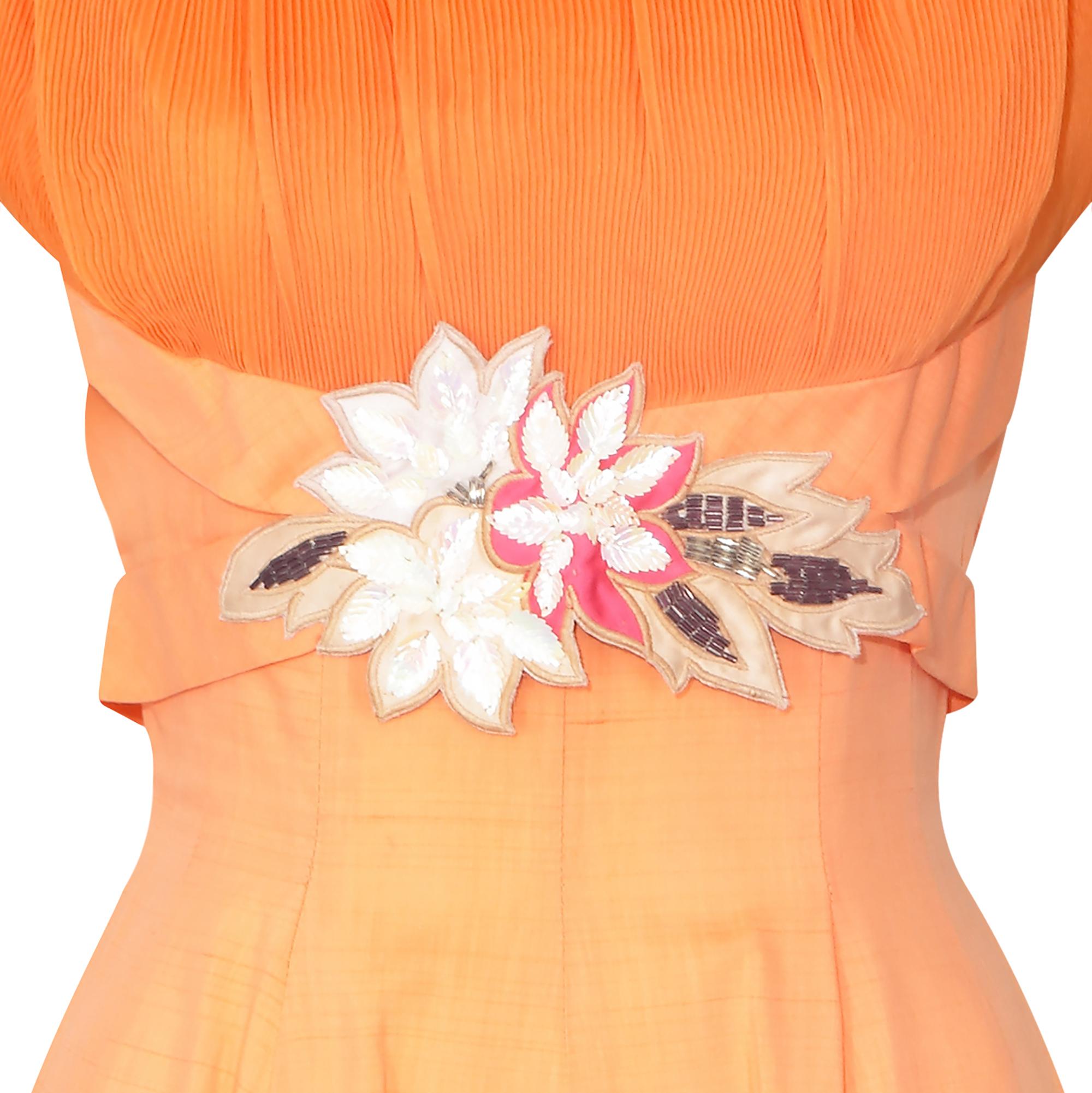 This original late 1950s or early 1960s dress has some really great design details and is in a delightful tangerine orange shade of cotton. We love the very fine accordion pleated shoulders and the Princess seamed and panelled waist gives the dress