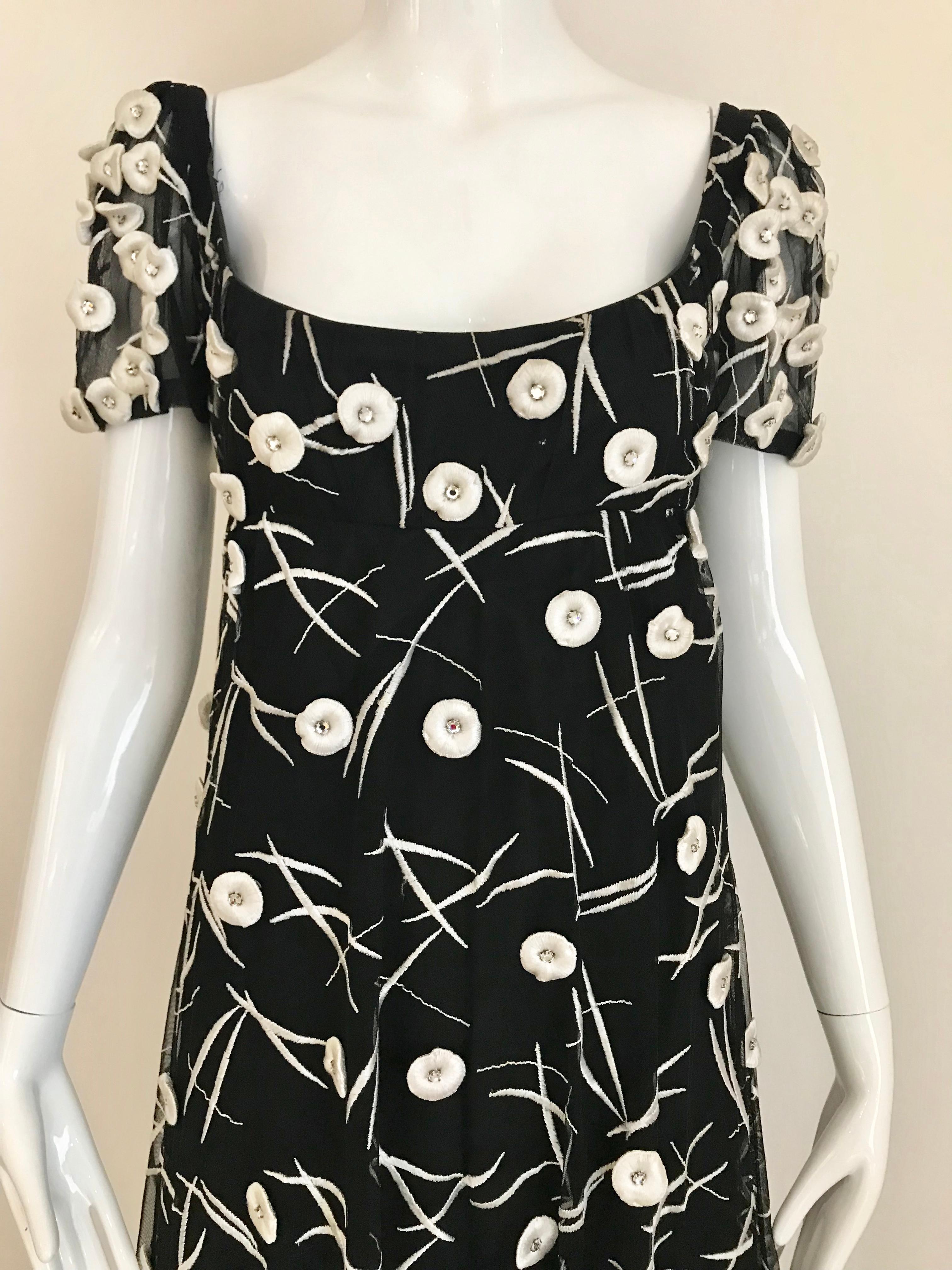 Beautiful 1960s Hardy Amies Black net gown with white circle appliqué with rhinestones. Scoop neck and empire waist.
Size: 6 ( see measurement) 
Bust: 36 inches/ Waist: 34 inches/ Hip 38 inches/ dress length: 54 inches