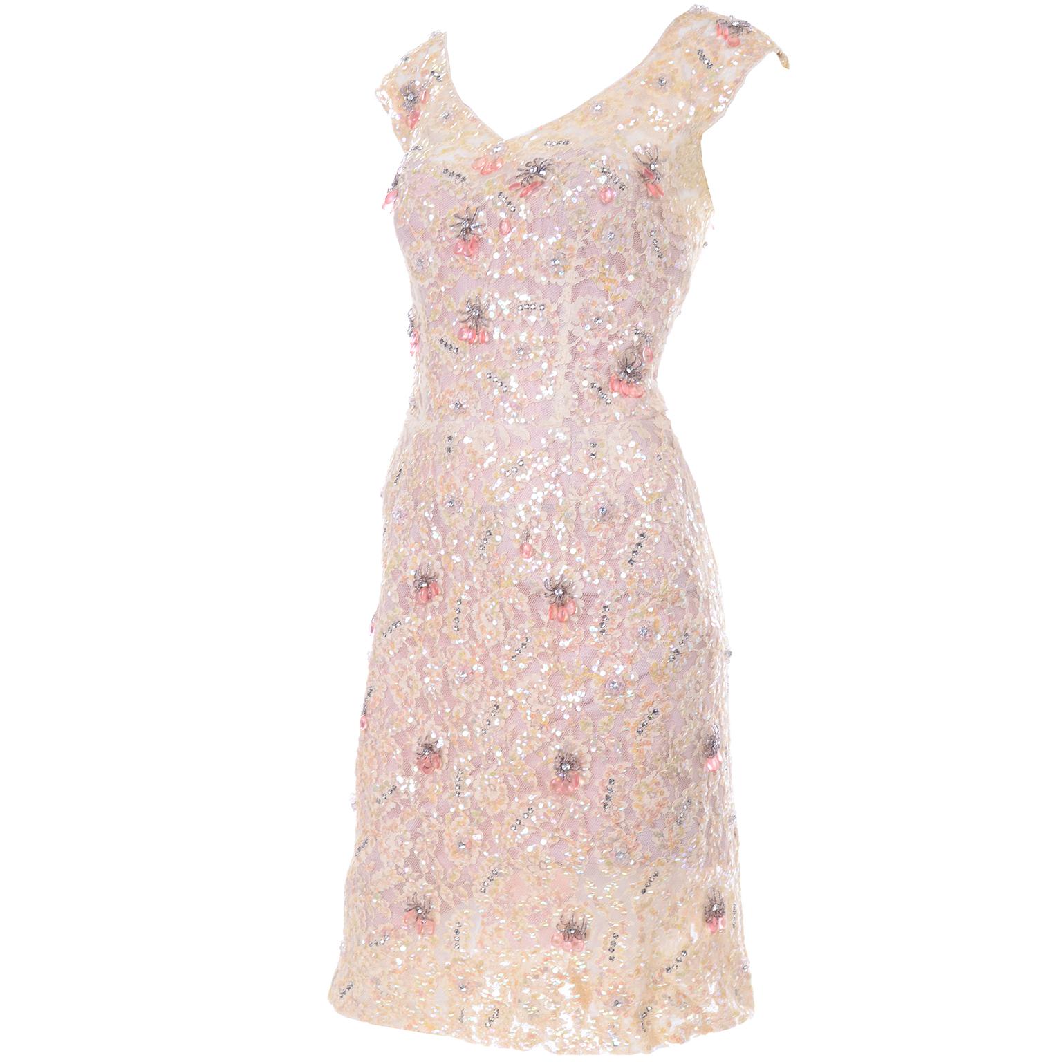 This is a stunning 1960's Harvey Berin wiggle dress with a pink satin lined sheer lace dress with an illusion bodice! The dress was designed by Karen Stark and has an outer dress that is covered with iridescent sequins forming flowers. There are