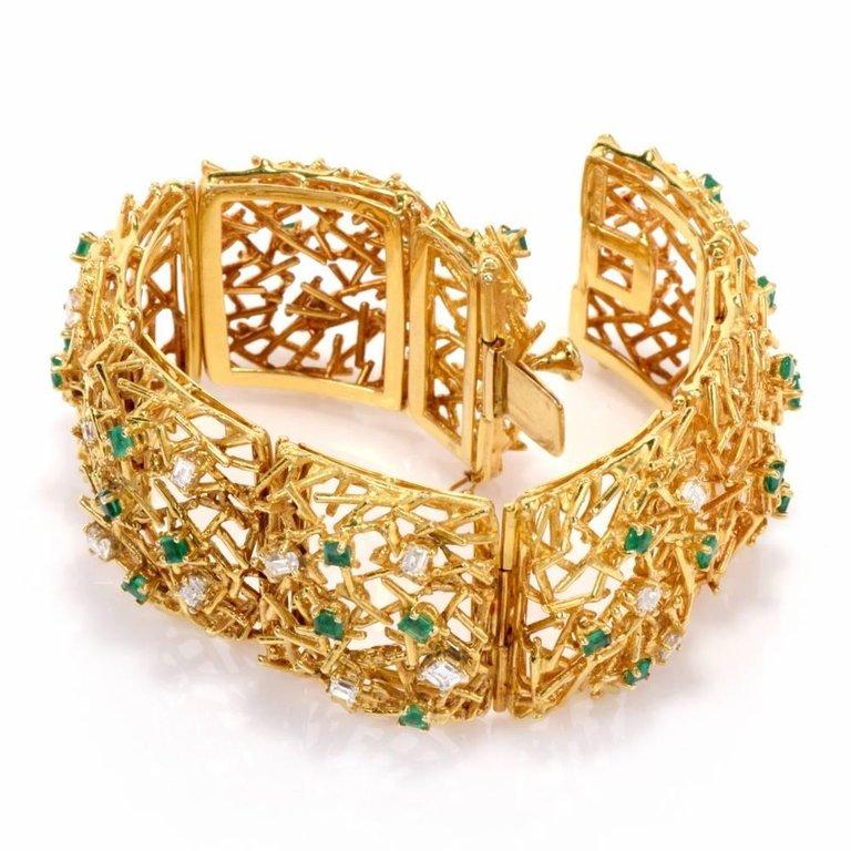 This impressive large wide bangle bracelet with diamonds and emeralds is intricately handcrafted in 18-karat yellow gold weighing an impressive 96.7 grams.

The bracelet measures 7.5 inches long and 28 mm wide.

This stunning bracelet is comprised