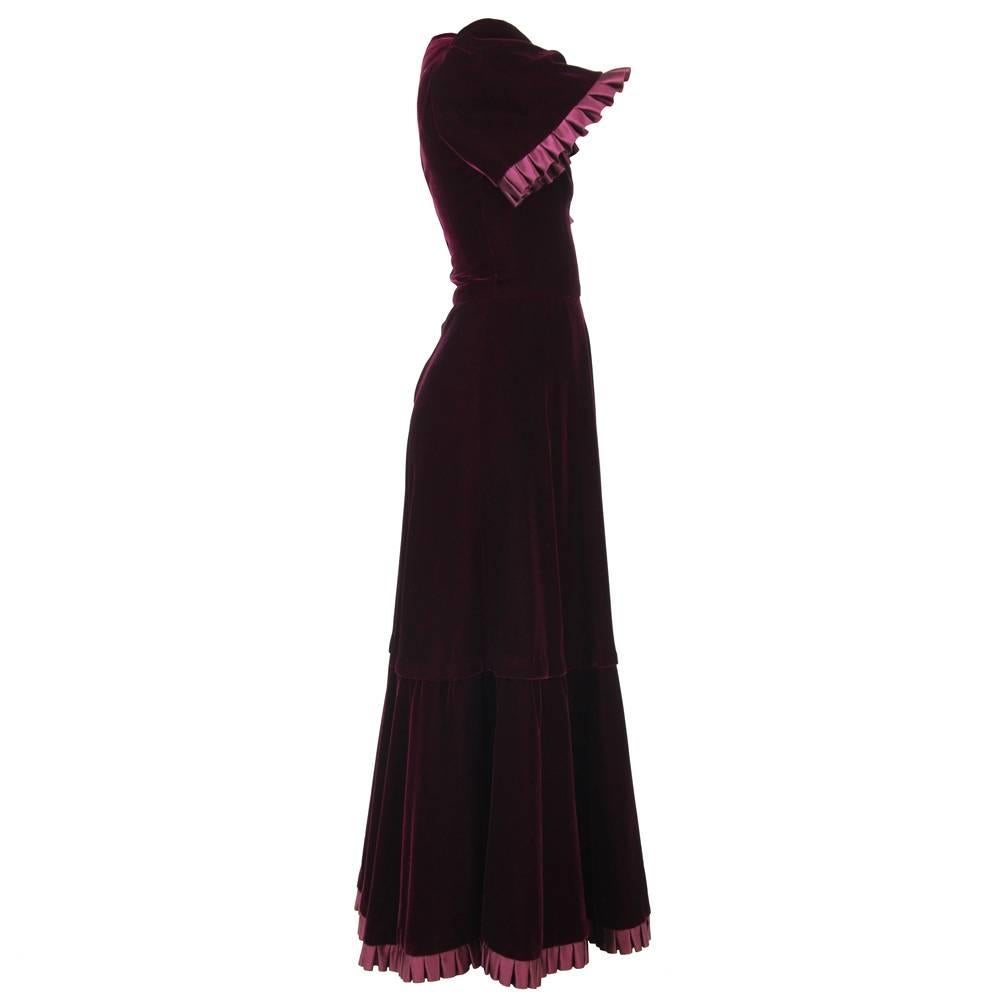 Magnificent and luxurious Heinz Riva maxi dress in a beautifully smooth burgundy velvet from the end of the 1960s. Features a chic frilly decoration on the edges of the sleeves and skirt. Very subtle split on the neckline.
Good