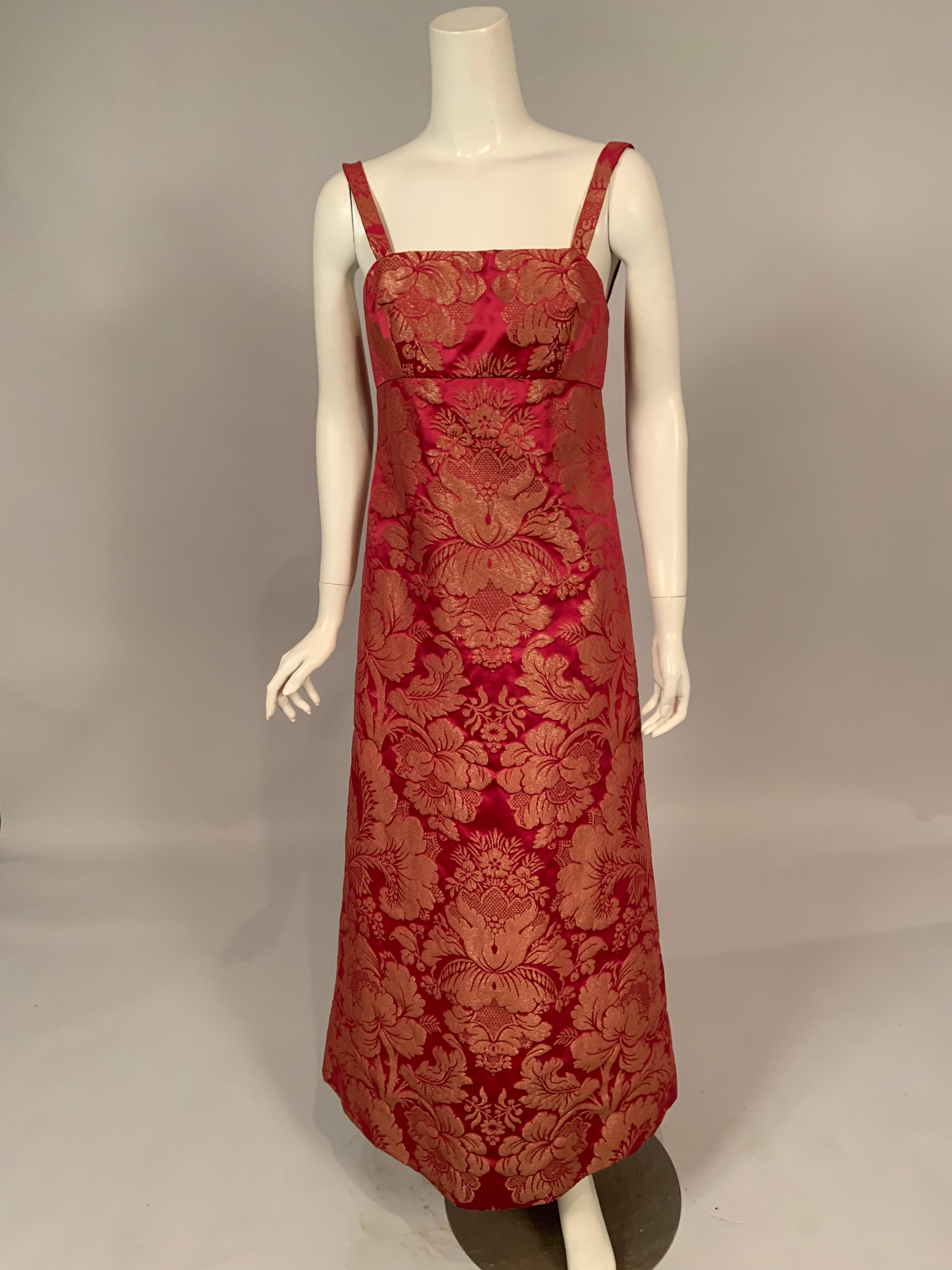 Helena Barbieri used a beautiful raspberry red silk with a woven metallic gold floral design for this chic 1960's dress and coat set. The dress has narrow straps an empire waistline and an elongated A line skirt. The boned bodice has a double zipper
