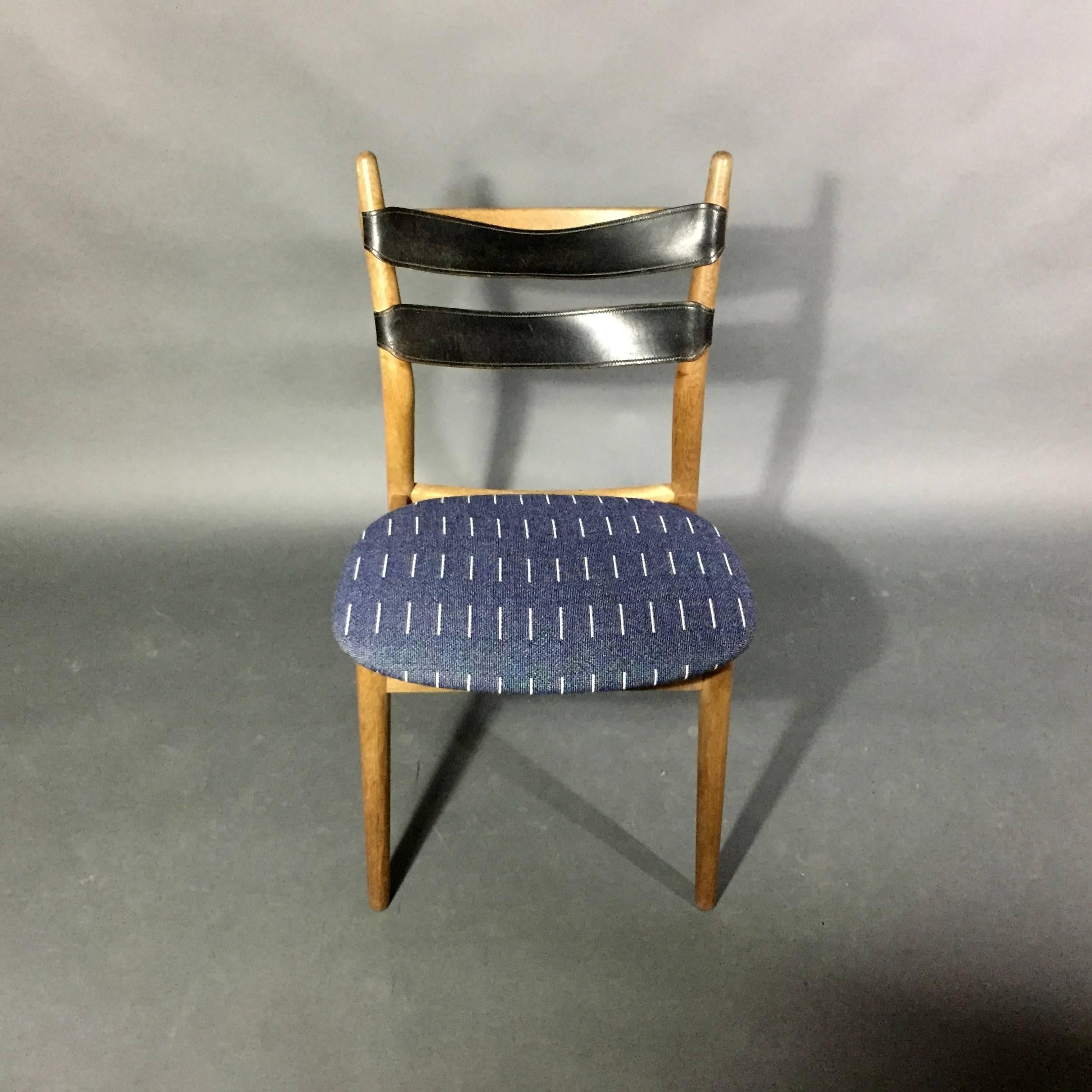 A rare design version from the prolific Helge Sibast of Denmark - this side, or dining chair, is made of solid oak with two original black leather straps at seat back in excellent condition. The seating upholstery has been updated by the amazing