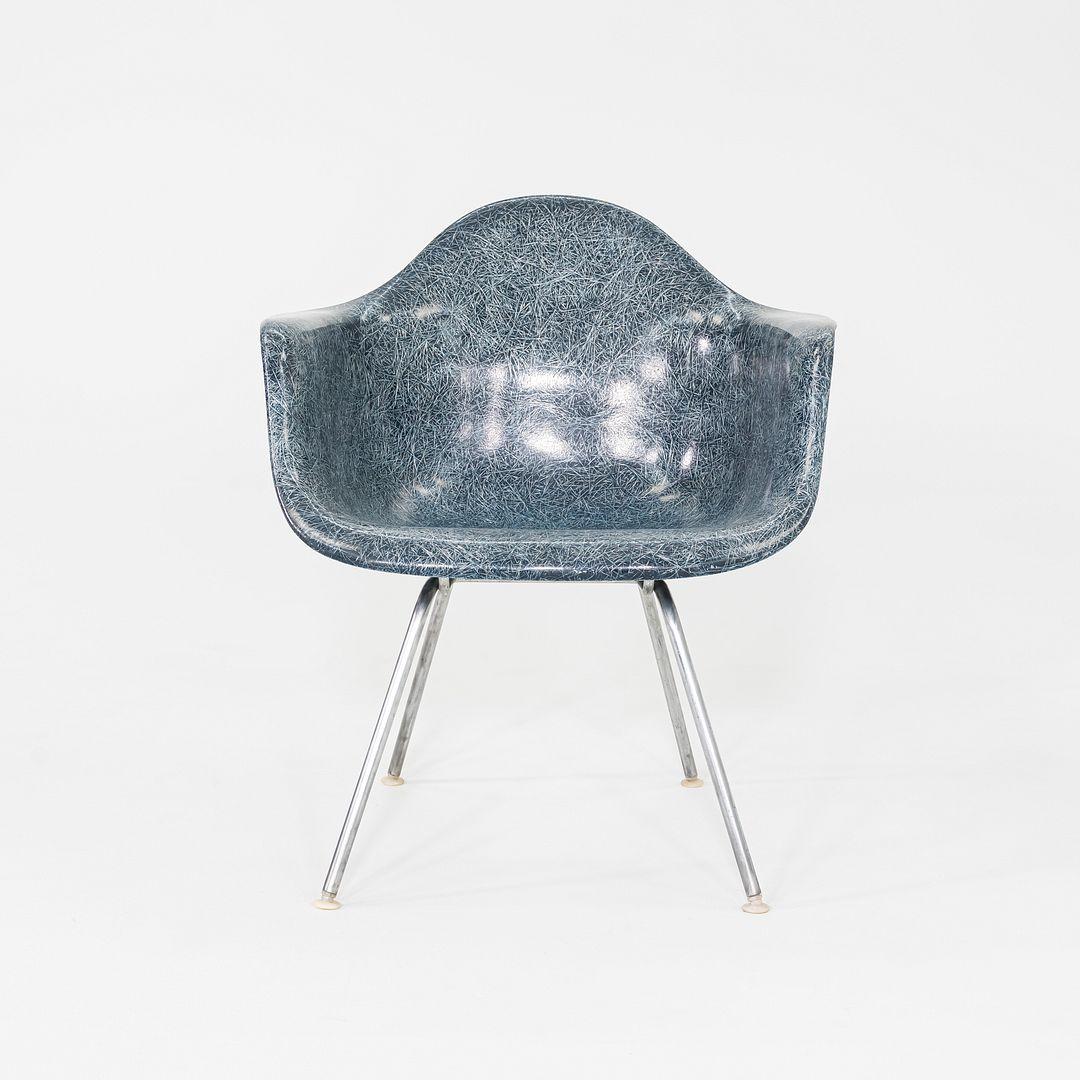 This is a MAX Armchair, originally designed by Ray and Charles Eames in 1953. This particular example was produced by Herman Miller in the USA in the 1960s. The shell seat of the chair is comprised of blue fiberglass, and the X-base is made with