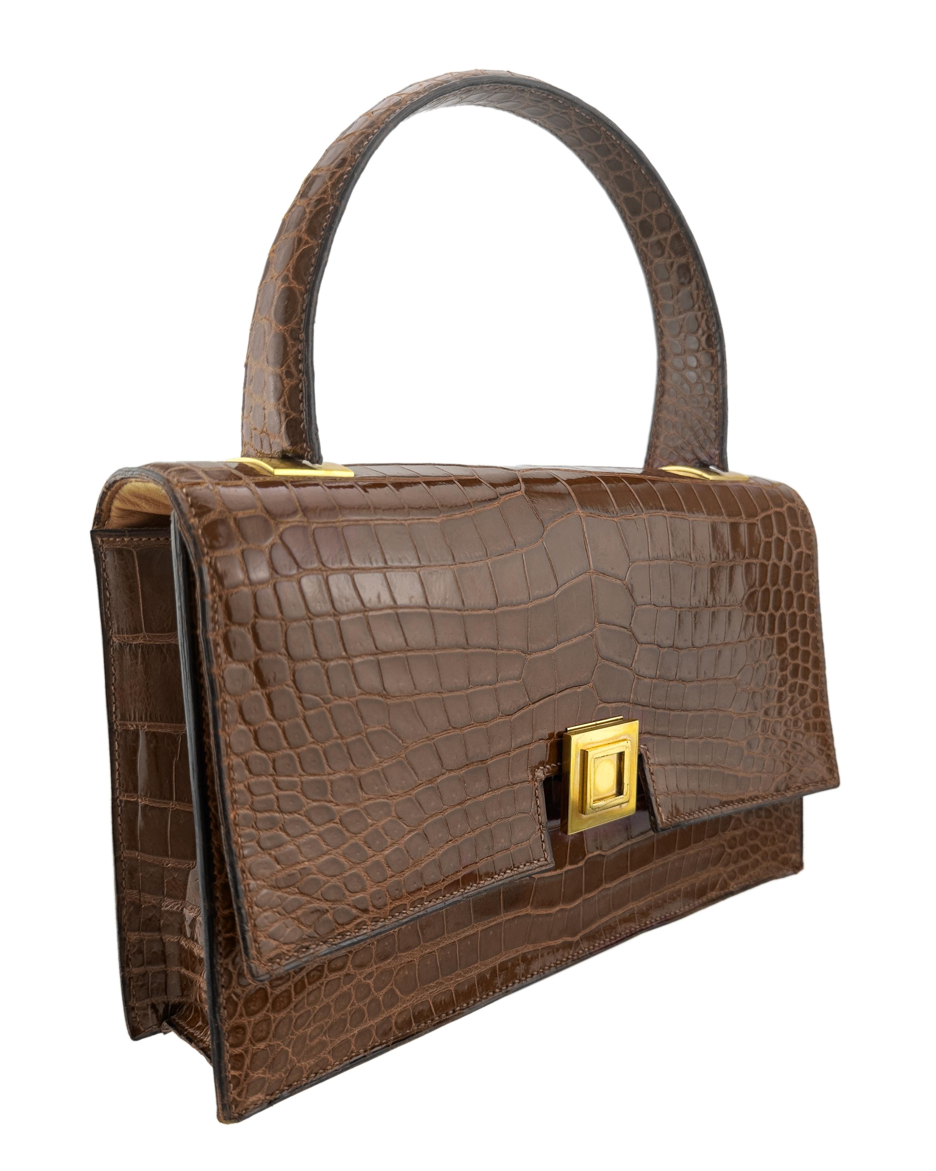 Superbe et rare sac Hermes des années 1960. Fabriqué à partir d'une peau de crocodile brillante et structurée de couleur brun toffee, avec des accessoires en métal de couleur or chaud contrastant. Fermoir carré intéressant qui glisse doucement vers
