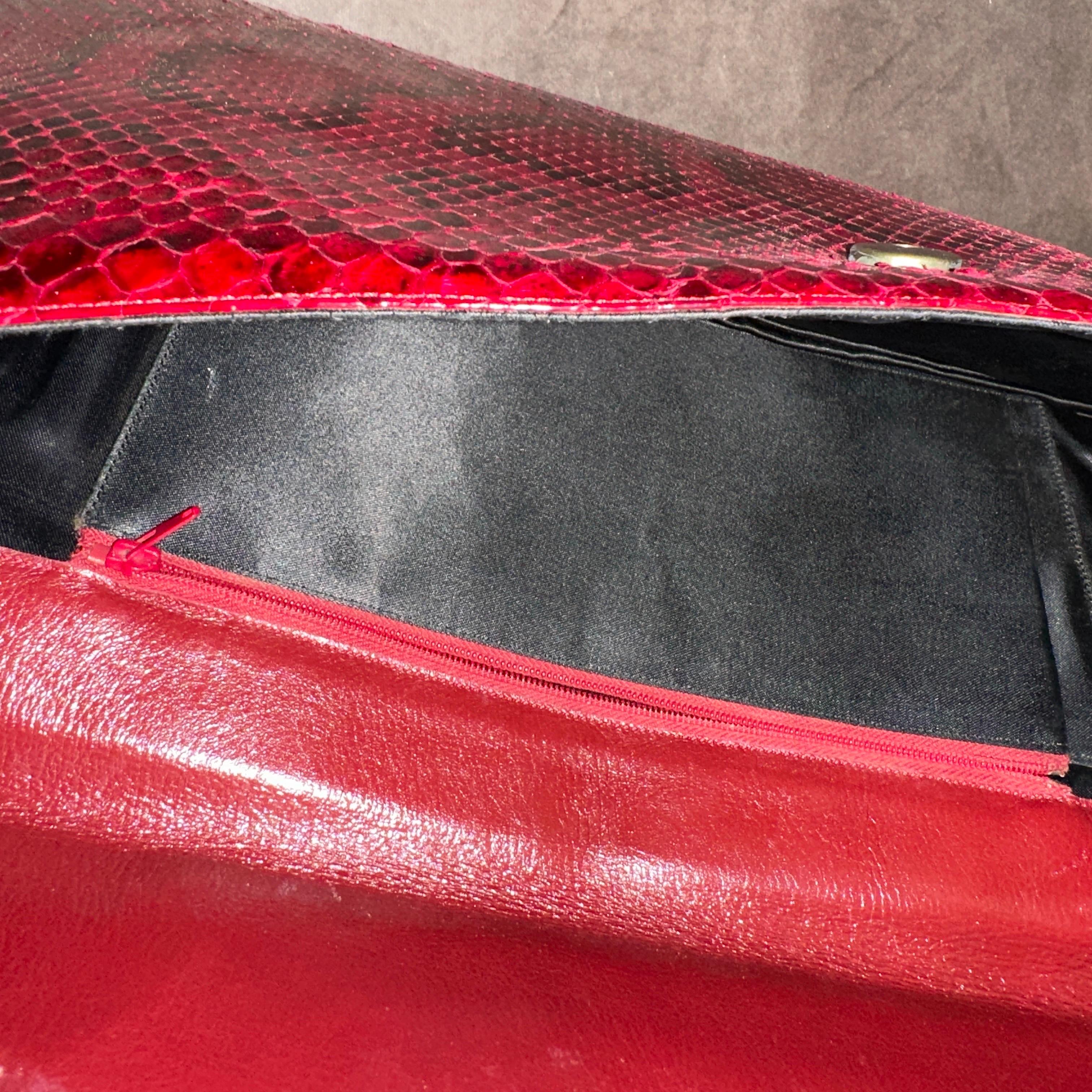 Il s'agit d'une superbe pochette en cuir italien rouge de haute qualité datant des années 1960. Cette pochette à rabat est fabriquée en cuir véritable avec une texture riche et vibrante imprimée en python rouge et noir, un matériau très recherché