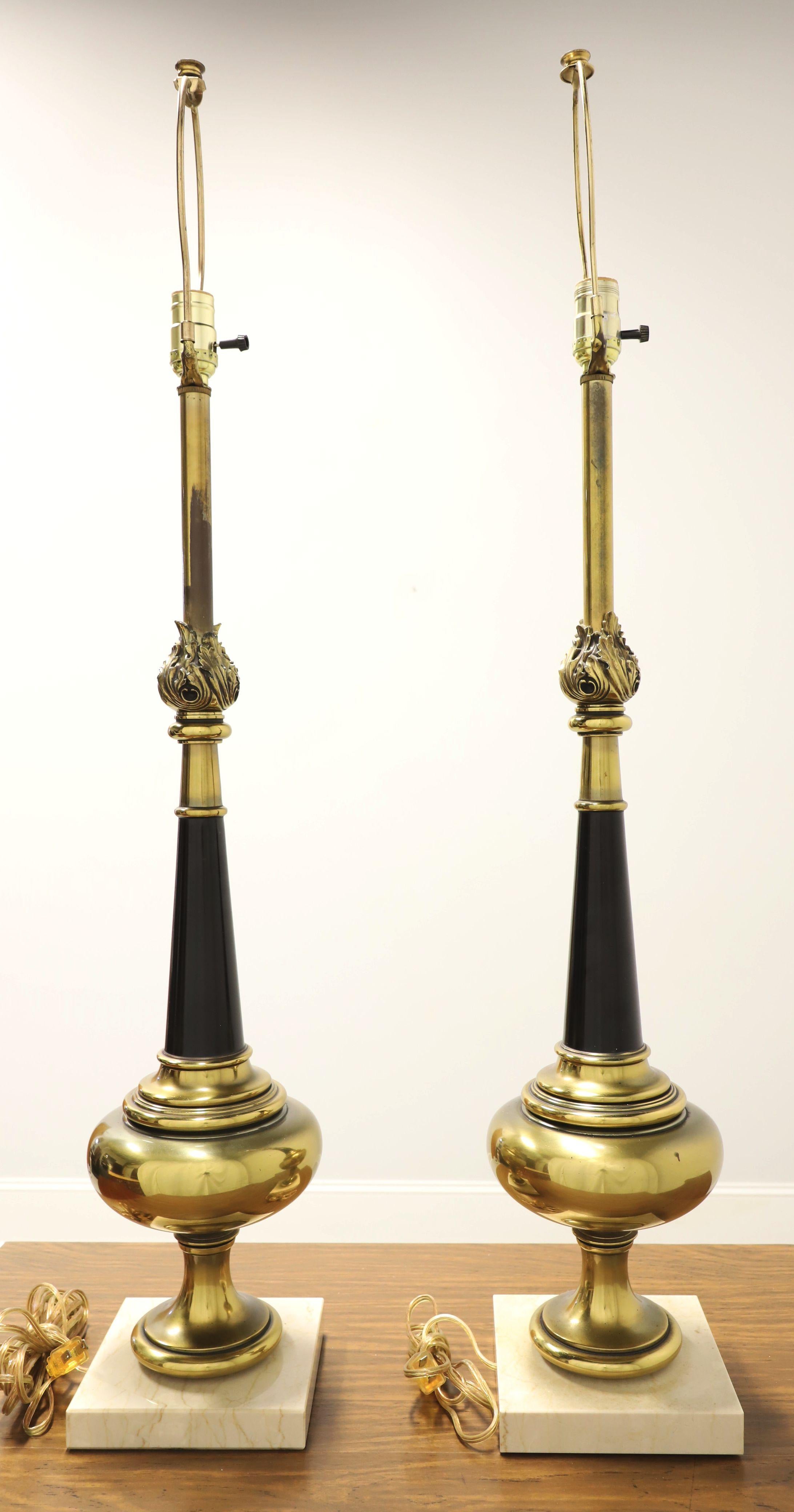 A pair of Hollywood Regency style table lamps, unbranded. Made of solid brass with an urn like shape, black painted center for accent, tall neck with decoratively molded top, and on an Italian genuine Carrara marble base. Has a removable metal harp