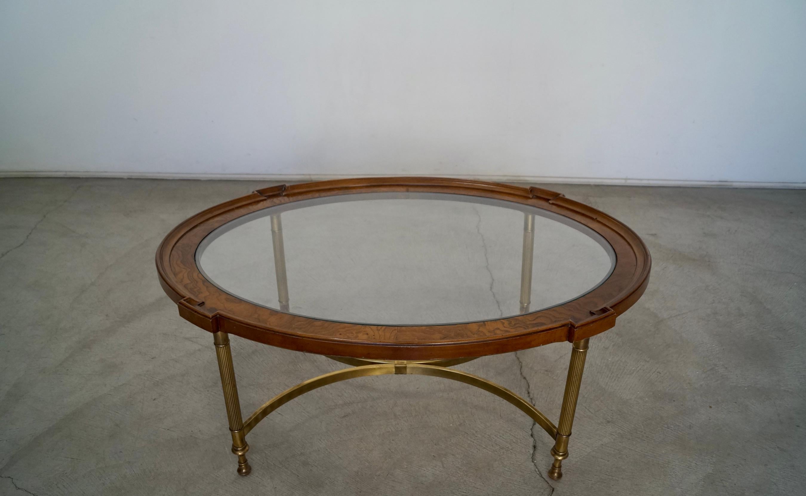 Vintage 1960's burl wood coffee table for sale. It was manufactured by Brandt Furniture, and is really well made. It has a solid brass base with brass stretchers, and a burl wood and glass top. It's in excellent condition, and is a beautiful table