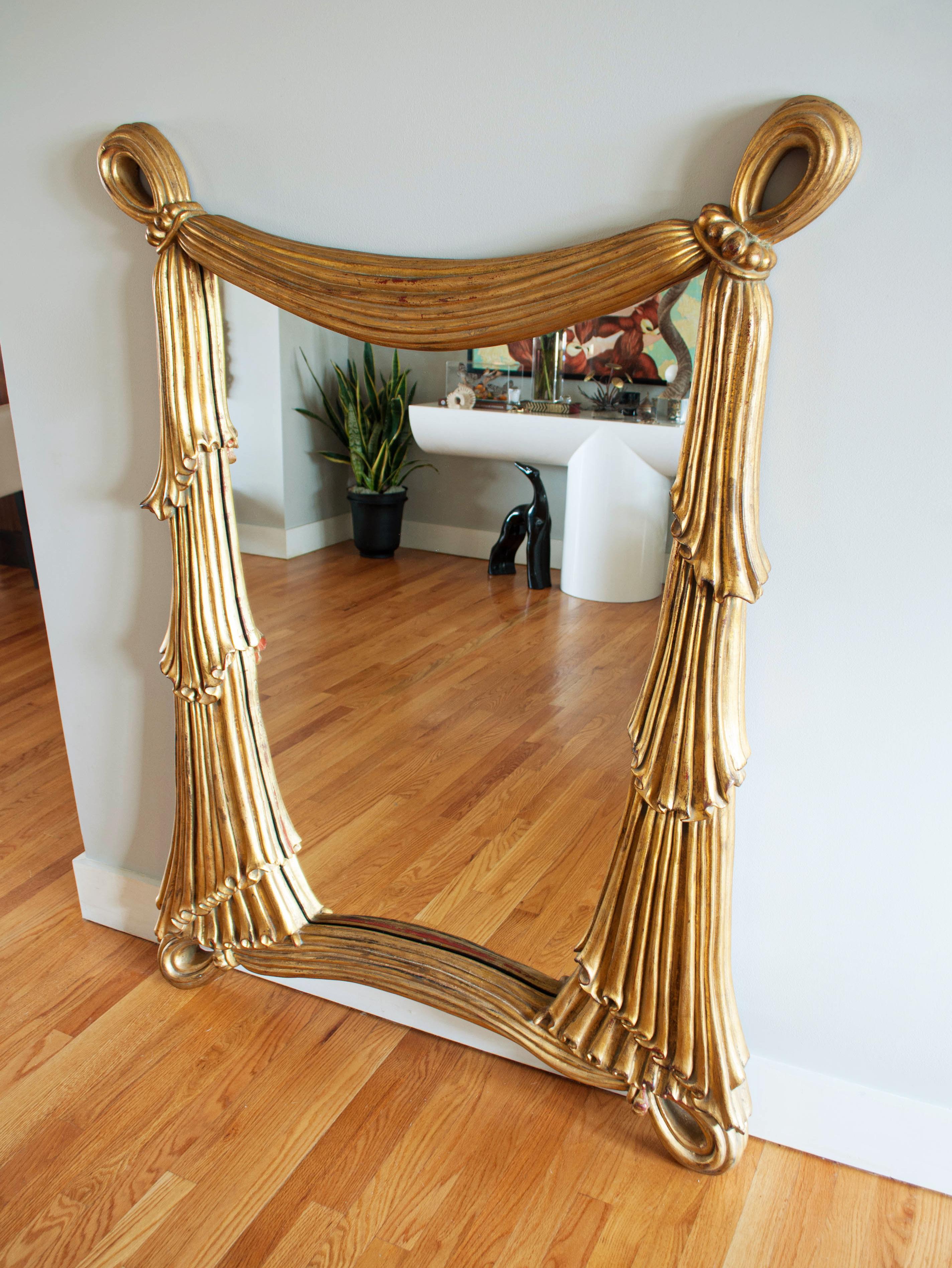 Absolutely stunning sculptural mirror depicting draped fabric. Beautifully executed, this grand mirror is painted to resemble gilded, hand carved wood.