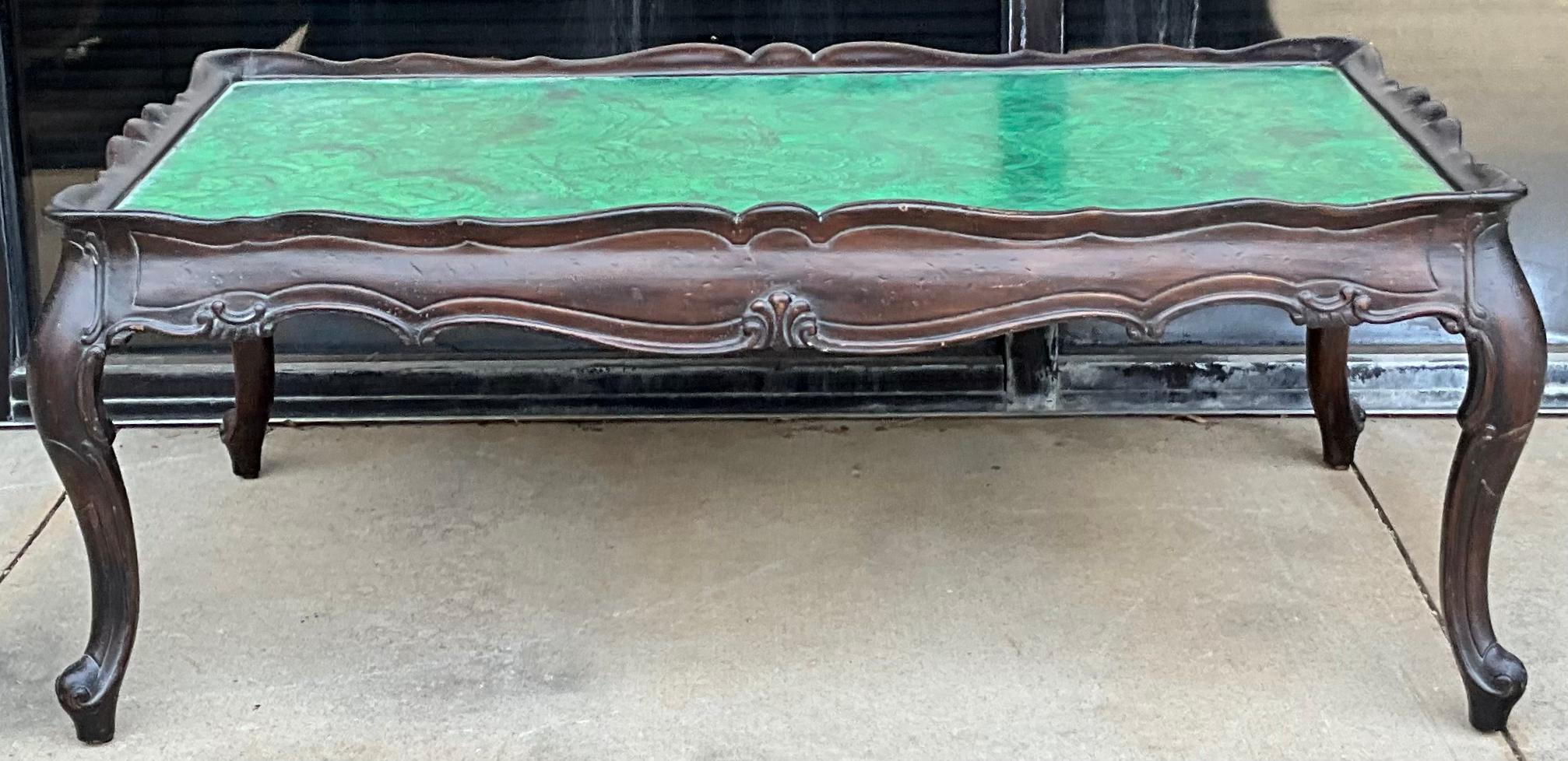 Il s'agit d'une table basse italienne sculptée en fausse malachite peinte, datant de l'époque Hollywood Regency. La base est fortement sculptée avec une finition presque ébonisée ou espresso. Le dessus en faux malachite peint parle de lui-même