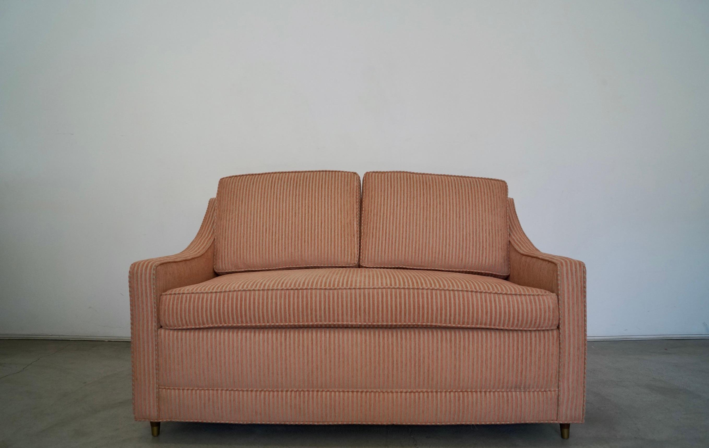 Vintage Mid-Century Modern sofa sleeper for sale. Original 1960s, and has been professionally reupholstered in a striped soft chenille velvet. The raised stripes are pink, and it has gray, coral, and silver. The metal pullout mechanism and mattress
