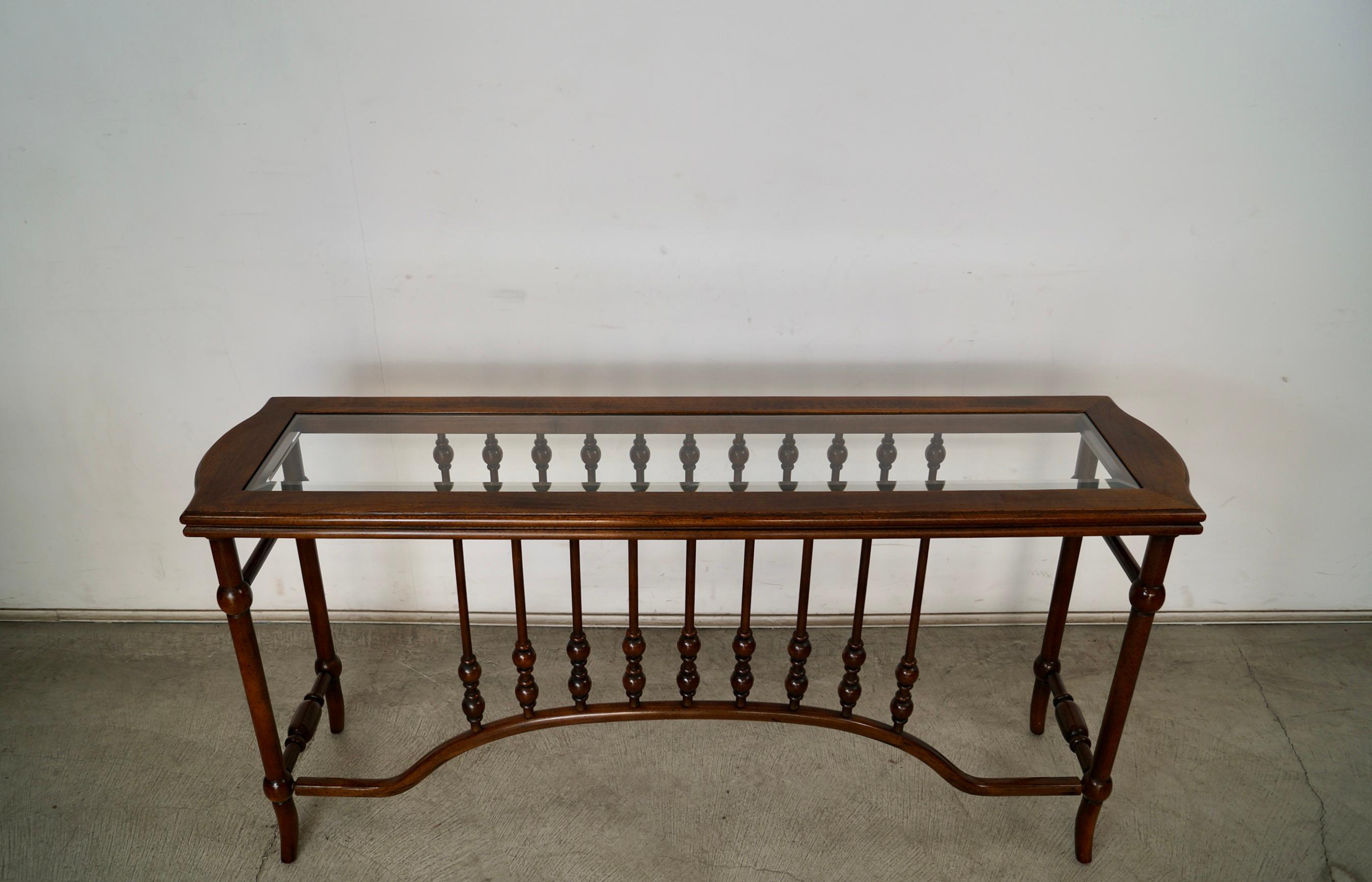 Vintage 1960's entrance table for sale. It's in excellent condition, and has a beautiful Spanish design. The wood finish is beautifully intact, and is a nice walnut tone. It has a beveled glass insert, and is a great length and depth for an entrance