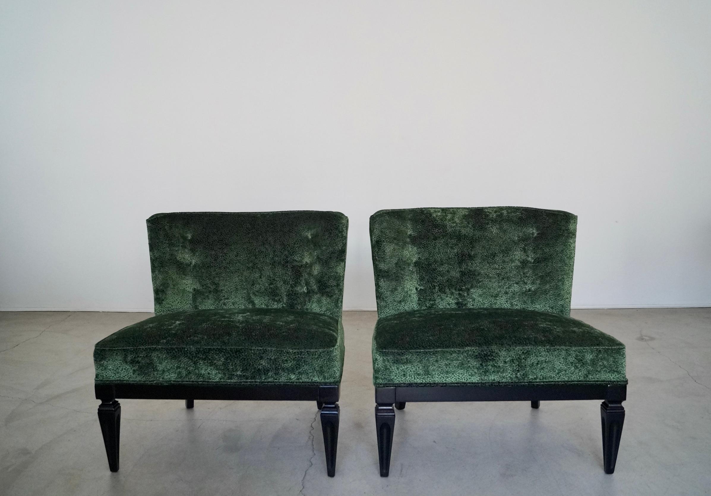 Vintage 1960's Hollywood Regency slipper chairs for sale. They have a solid wood base that have been refinished in black, and have been reupholstered in a high-end velvet by Robert Allen in emerald with an incredible texture. The velvet has a nice