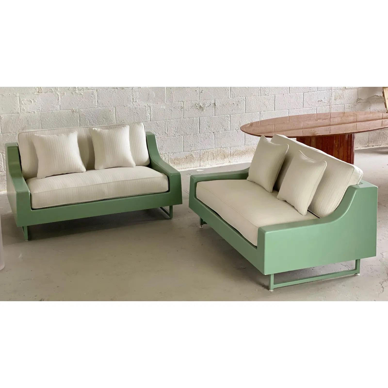 We are very pleased to offer a rare, modern pair of sofas by Homecrest, circa the 1960s. This super sleek pair showcases an outdoor shell made of fiberglass and impregnated with polyester resin. A steel frame is then secured around the inside