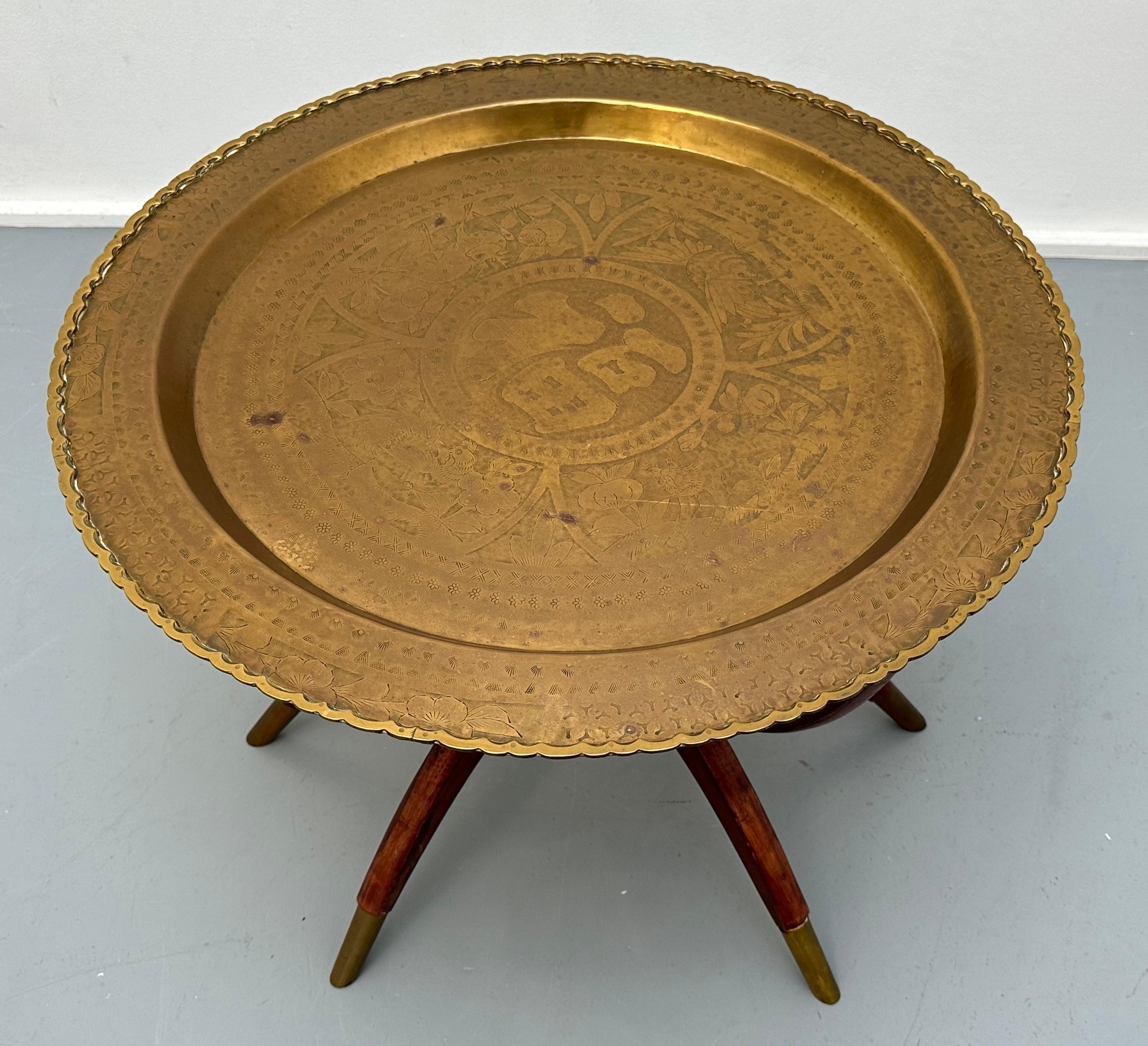 1960s coffee or side table which is perfect for serving afternoon coffee or tea because of its height. Made in Hong Kong which is stamped on the back of the brass circular removable tray table top. The six stained dark red wooden spider-leg