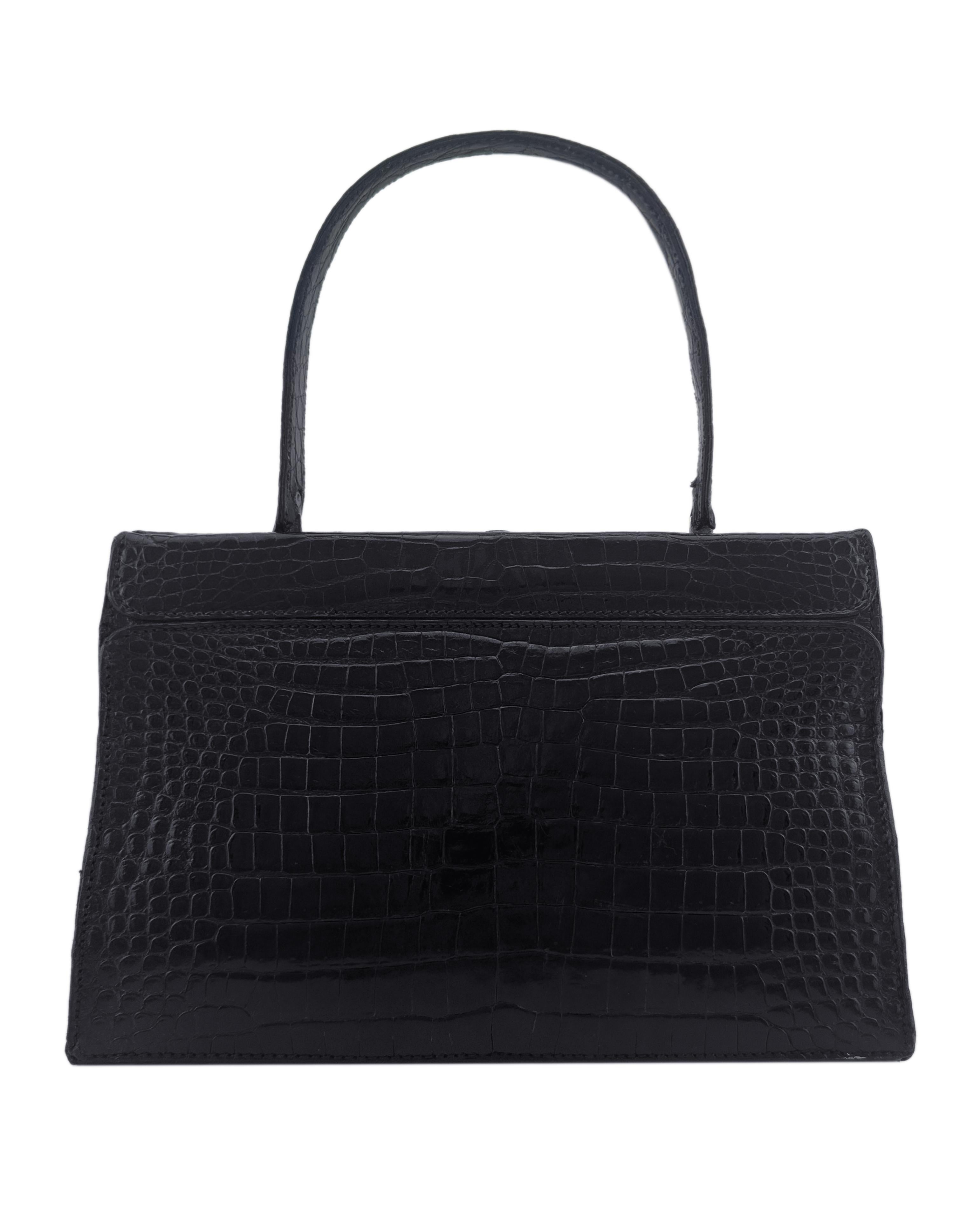 Sac à cadre en peau de crocodile noir brillant de la maison Grimaldi, datant des années 1960. Poignée supérieure avec fermeture à pression et détails intéressants de la corde en métal à travers les œillets en métal aux coins supérieurs avant gauche