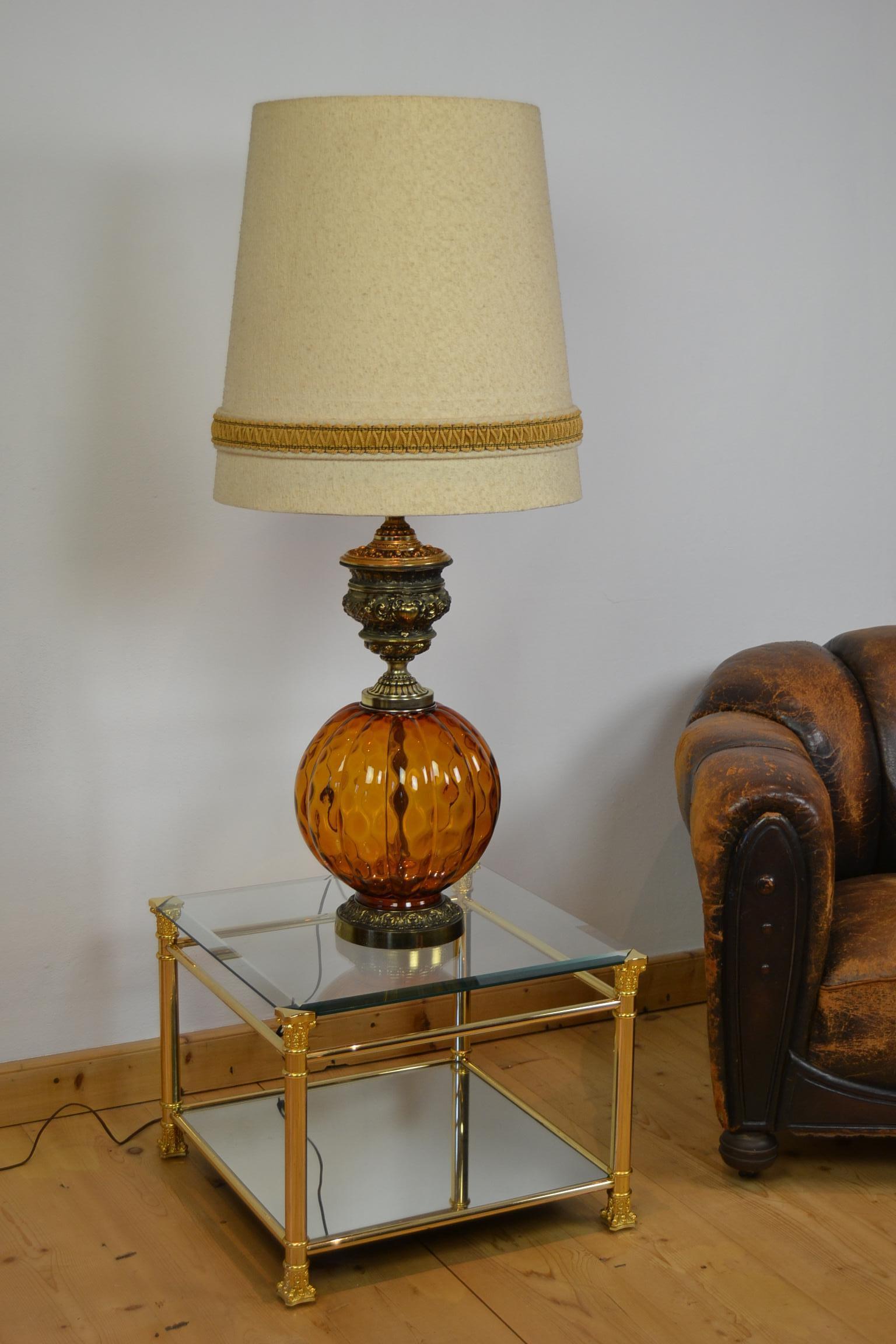 Spectacular huge table lamp or floor lamp with amber blown art glass.
This vintage lamp dates from the 1960s and wears a very beautiful large fabric shade.
Due his size it's an eye-catching and impressive light so can be used as a table lamp or as