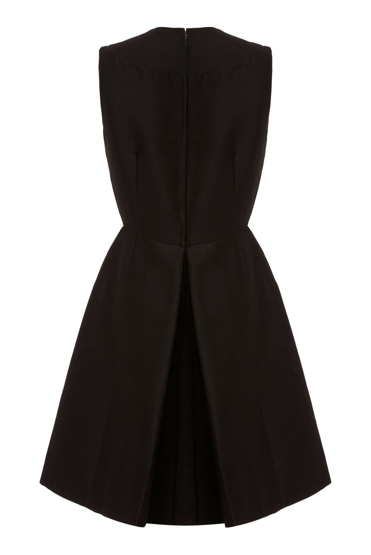 This 1960s chic black silk - wool blend mod-style cocktail dress from high end American department store I. Magnin is of excellent quality and is in pristine vintage condition. This versatile piece is sleeveless with a knee length skirt that flares