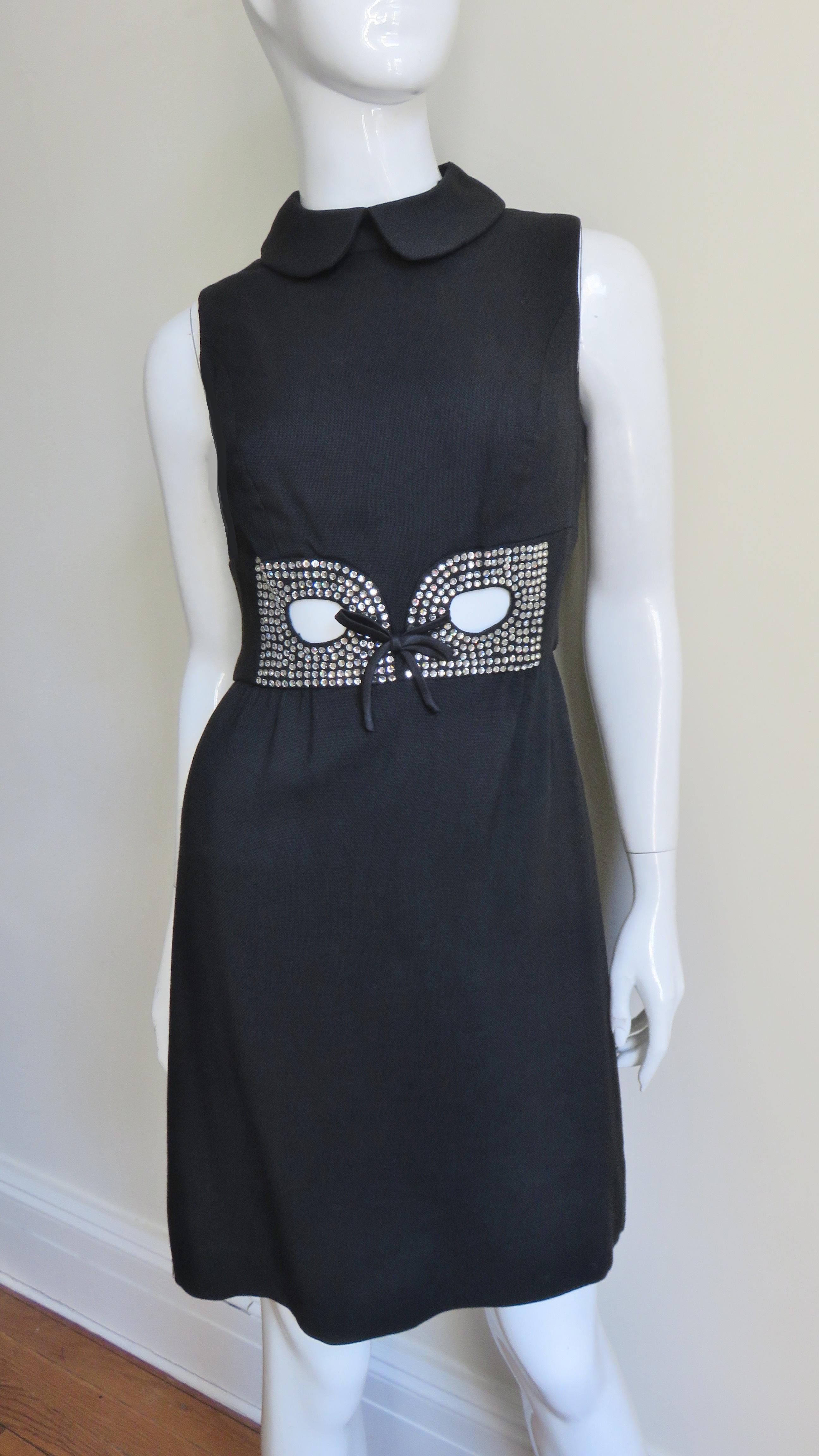 A great black 1960s linen dress from I.Magnin.  It is sleeveless with a peter pan collar and princess seaming for a terrific fit.  There is a panel around the waist with small prong set rhinestone embellished cut outs at the center front and the