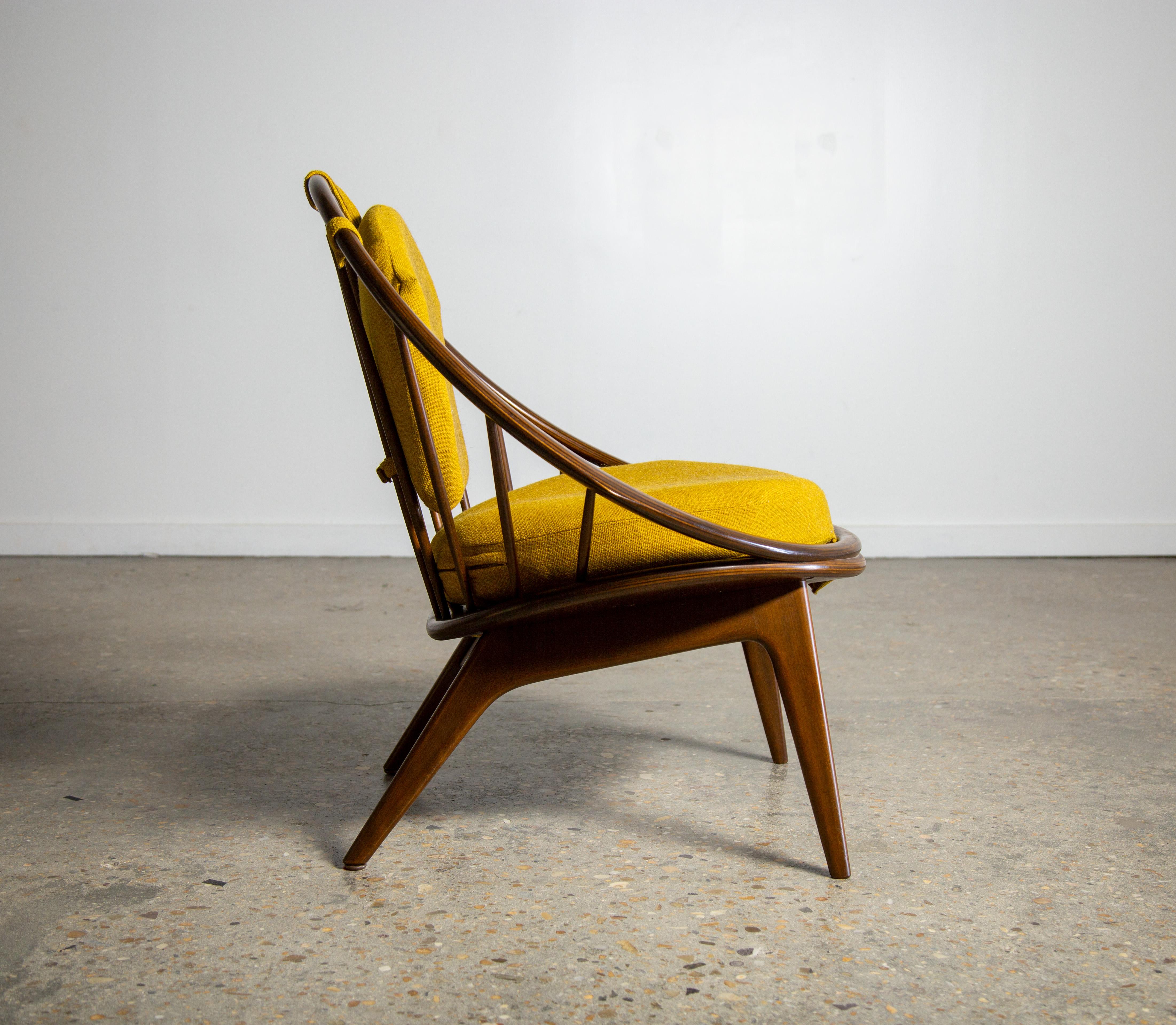 The Hoop Chair designed by Ib Kofod Larsen and imported by Selig. This example from the 1960s shows very well. A darker stain on the Birch and new Yellow Danish wool and cushions. This chair is ready to go another 60 years. Retains its original