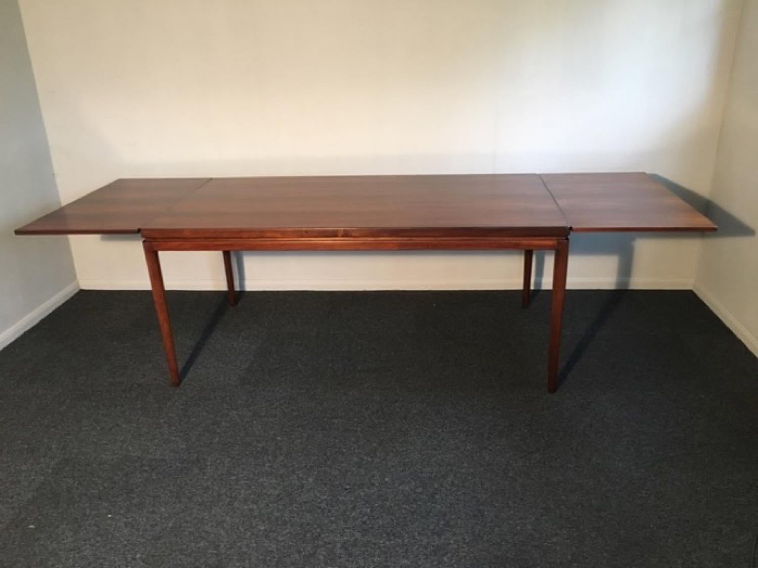 A stunning, large, Danish rosewood dining table, designed by Ib Kofod-Larsen and manufactured by Christian Linneberg in the 1960s. In very good vintage condition having been refinished, polished and waxed. The table has two extension leaves that